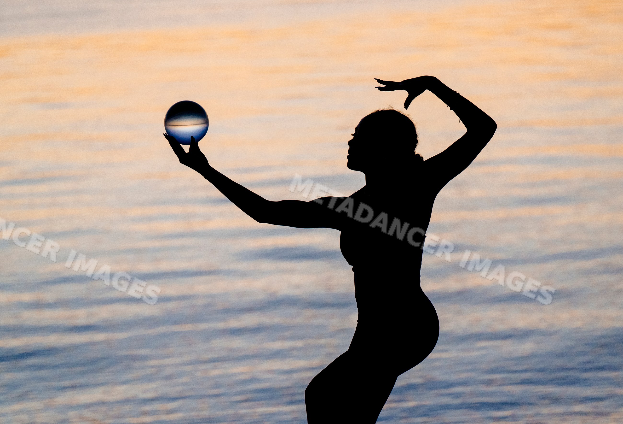 Silhouette of a Hispanic woman performing yoga acrobatic pose