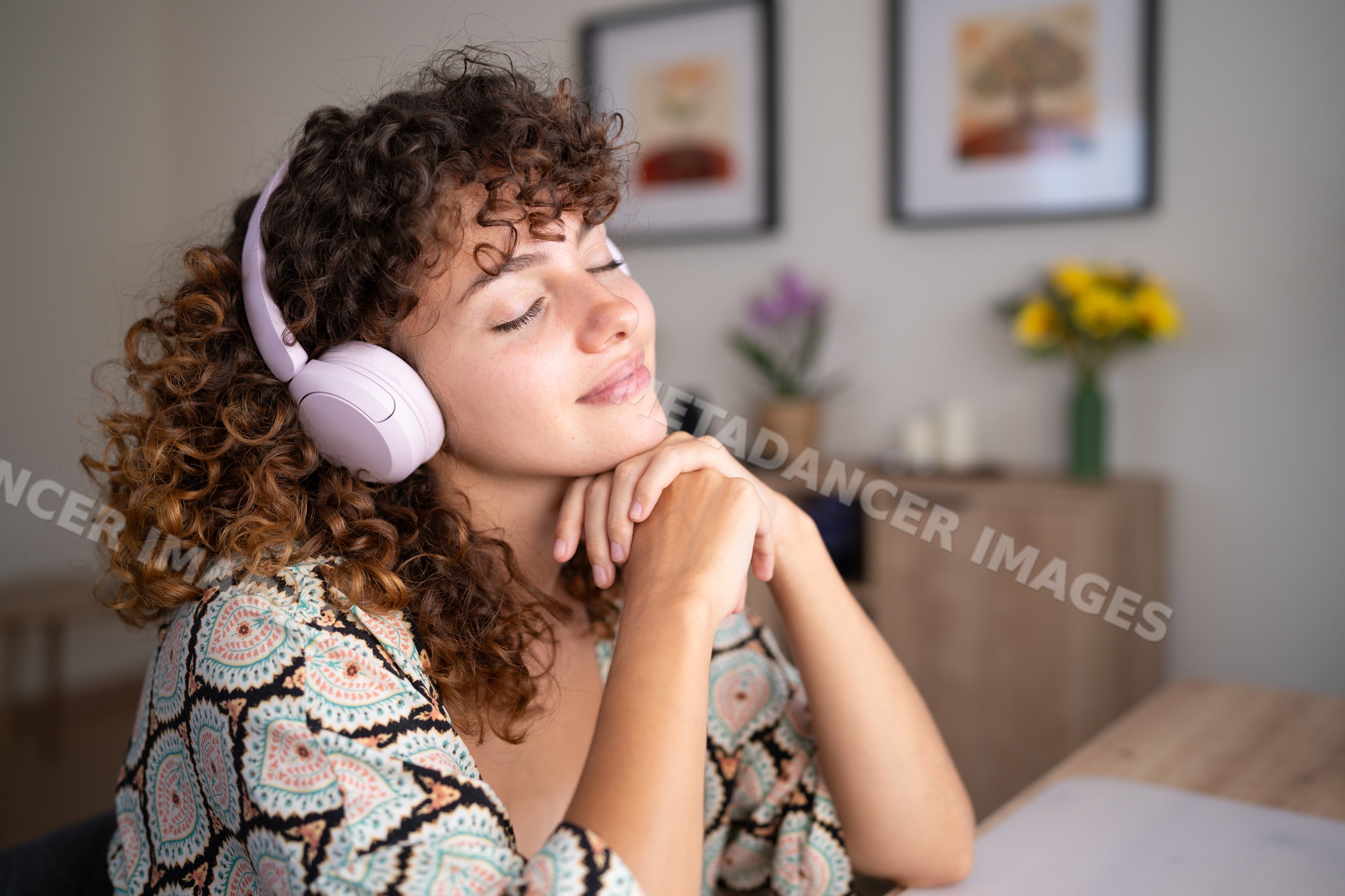 White woman relaxing at home listening to music with headphones