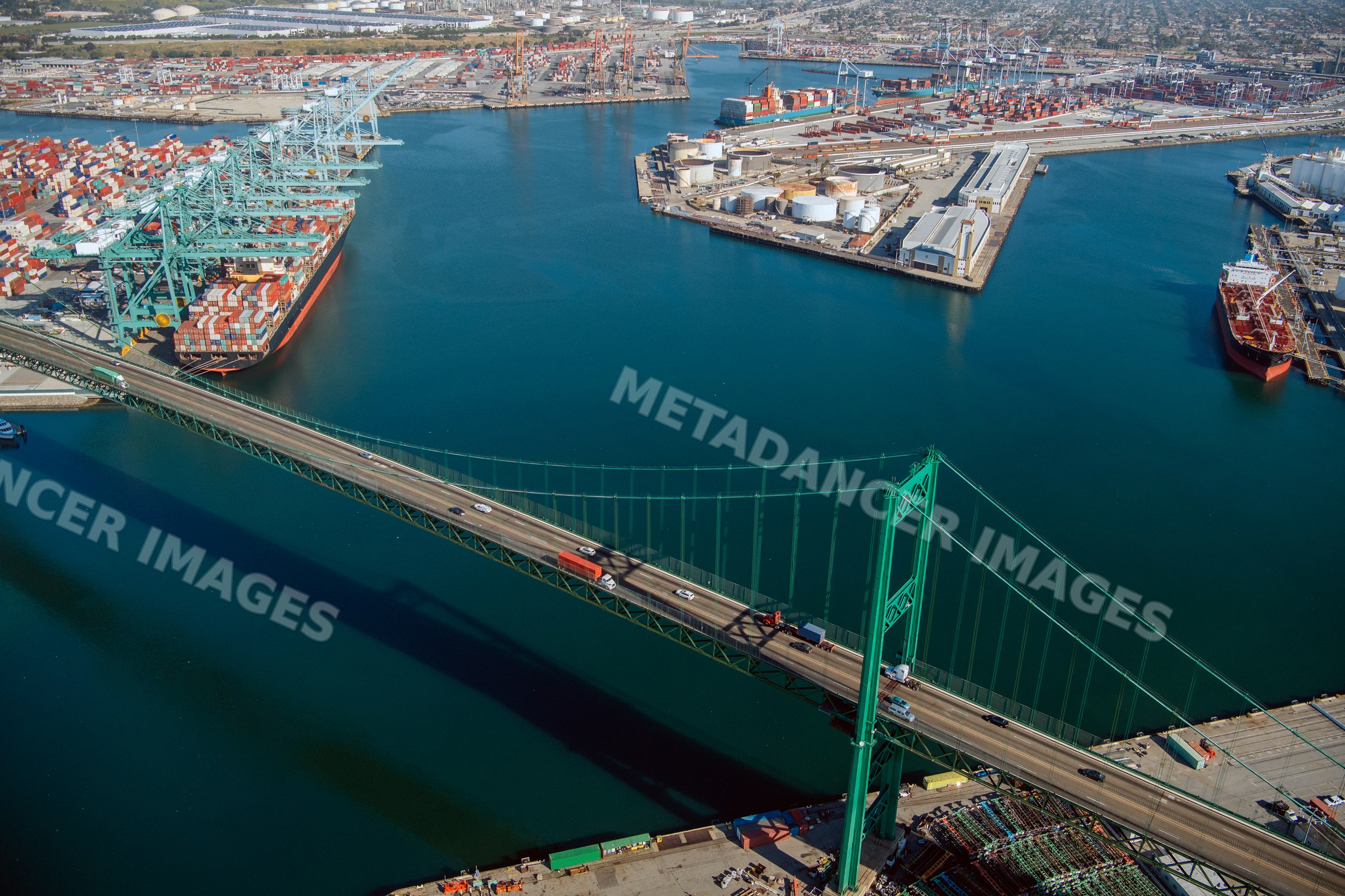 Suspension bridge over shipping port with container ships