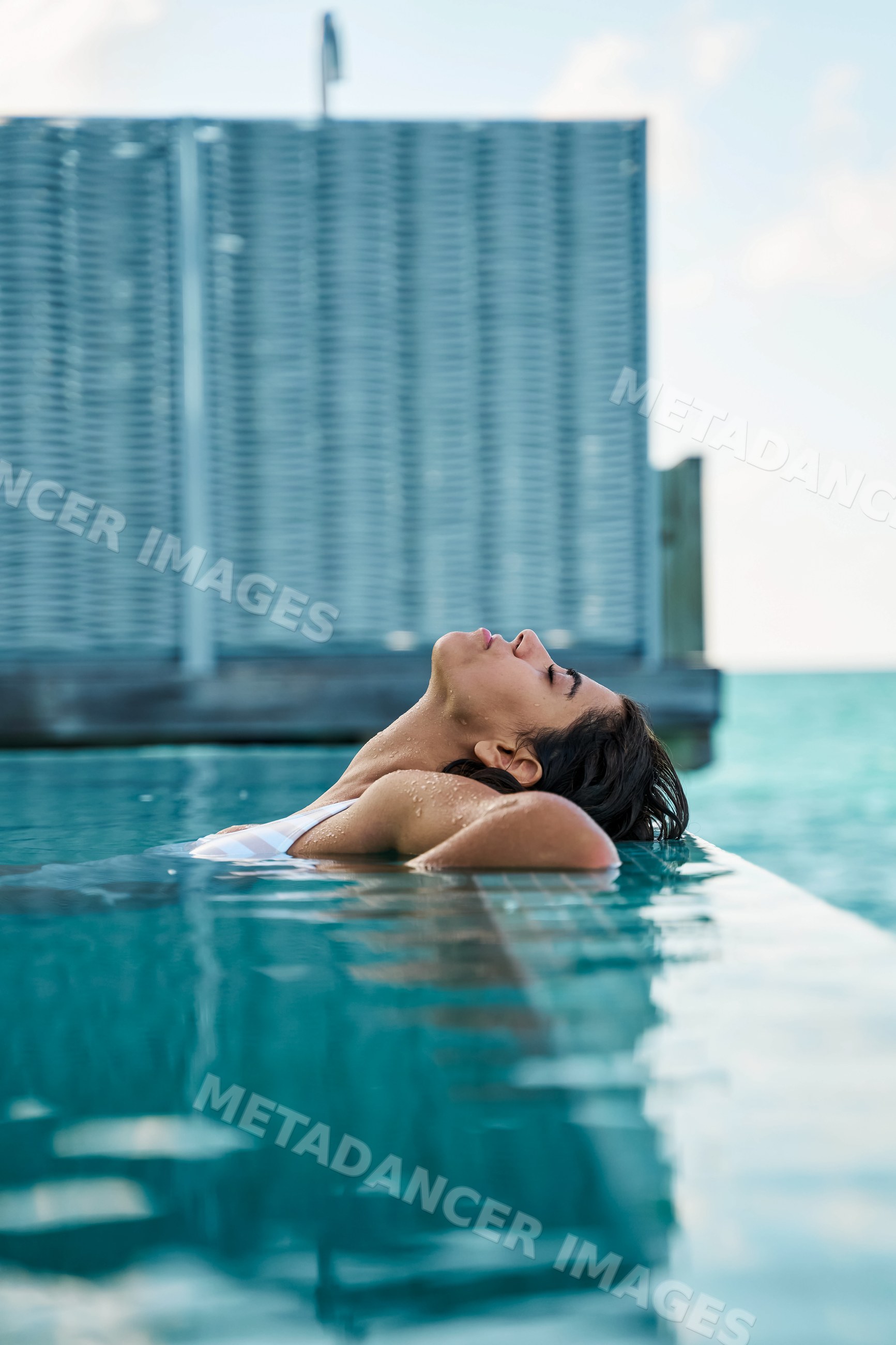 A white woman relaxing in a swimming pool at a resort