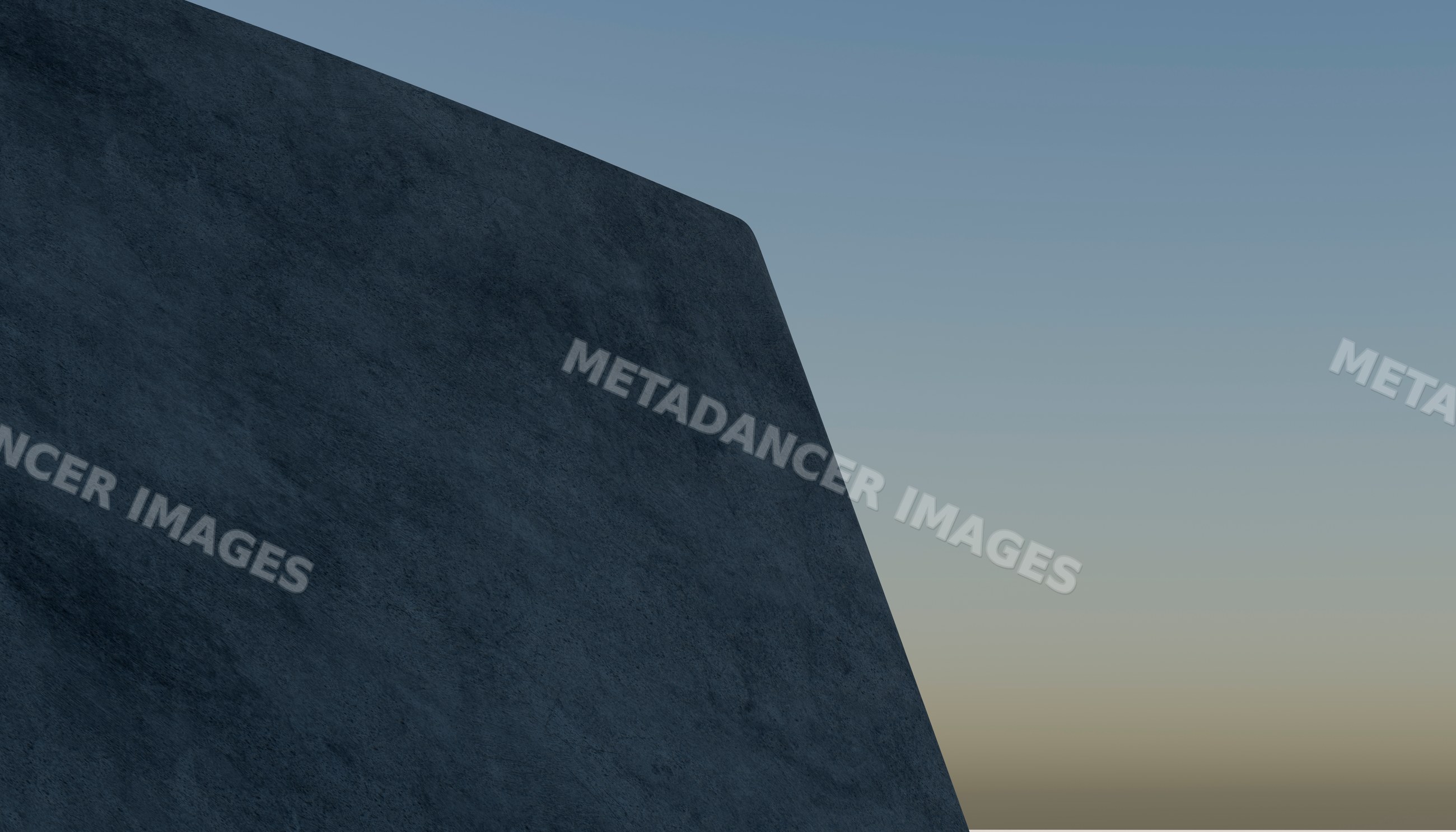 A large concrete wall of a modern building against a clear sky