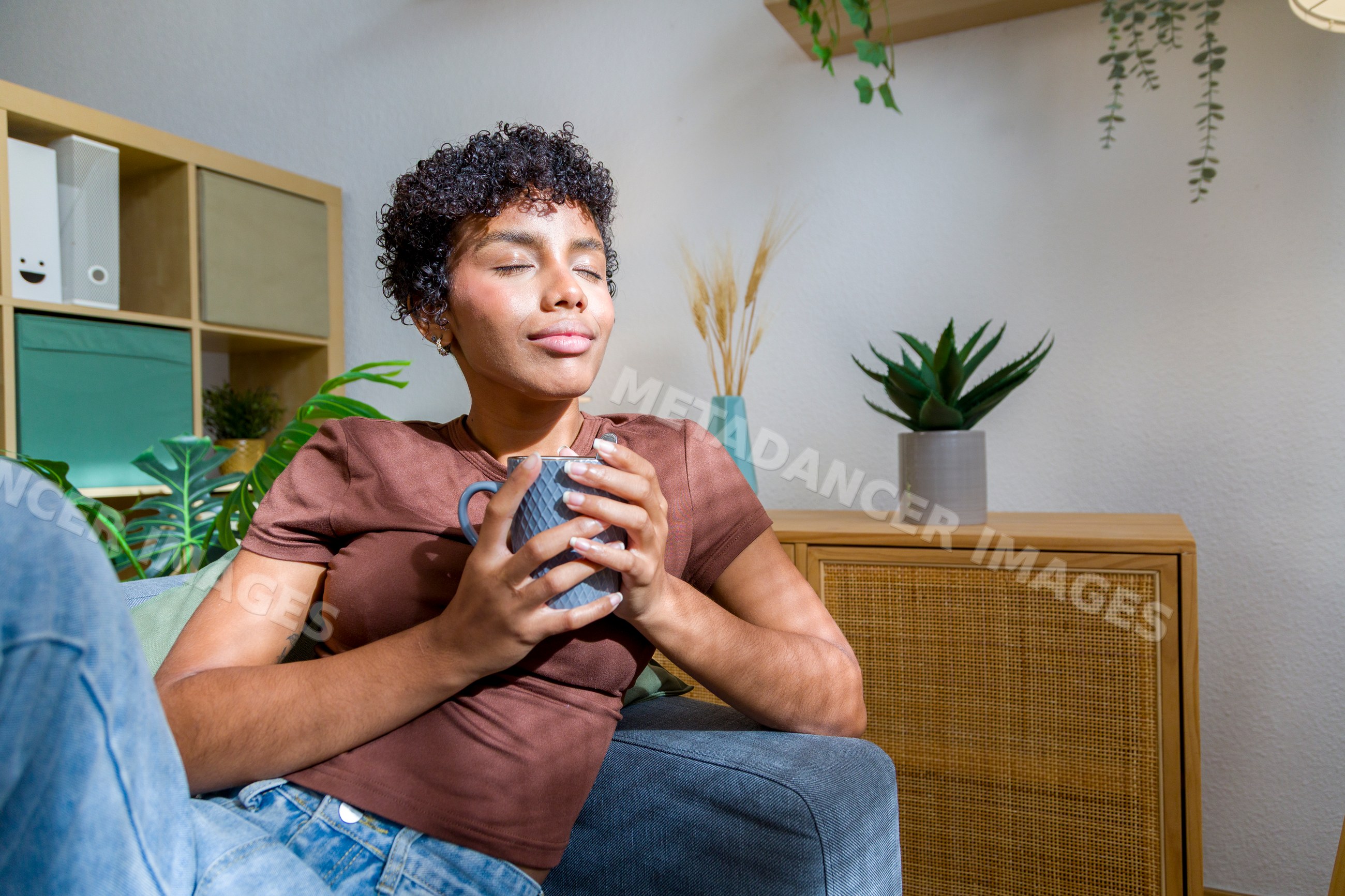 African American woman relaxing at home holding a mug in living room