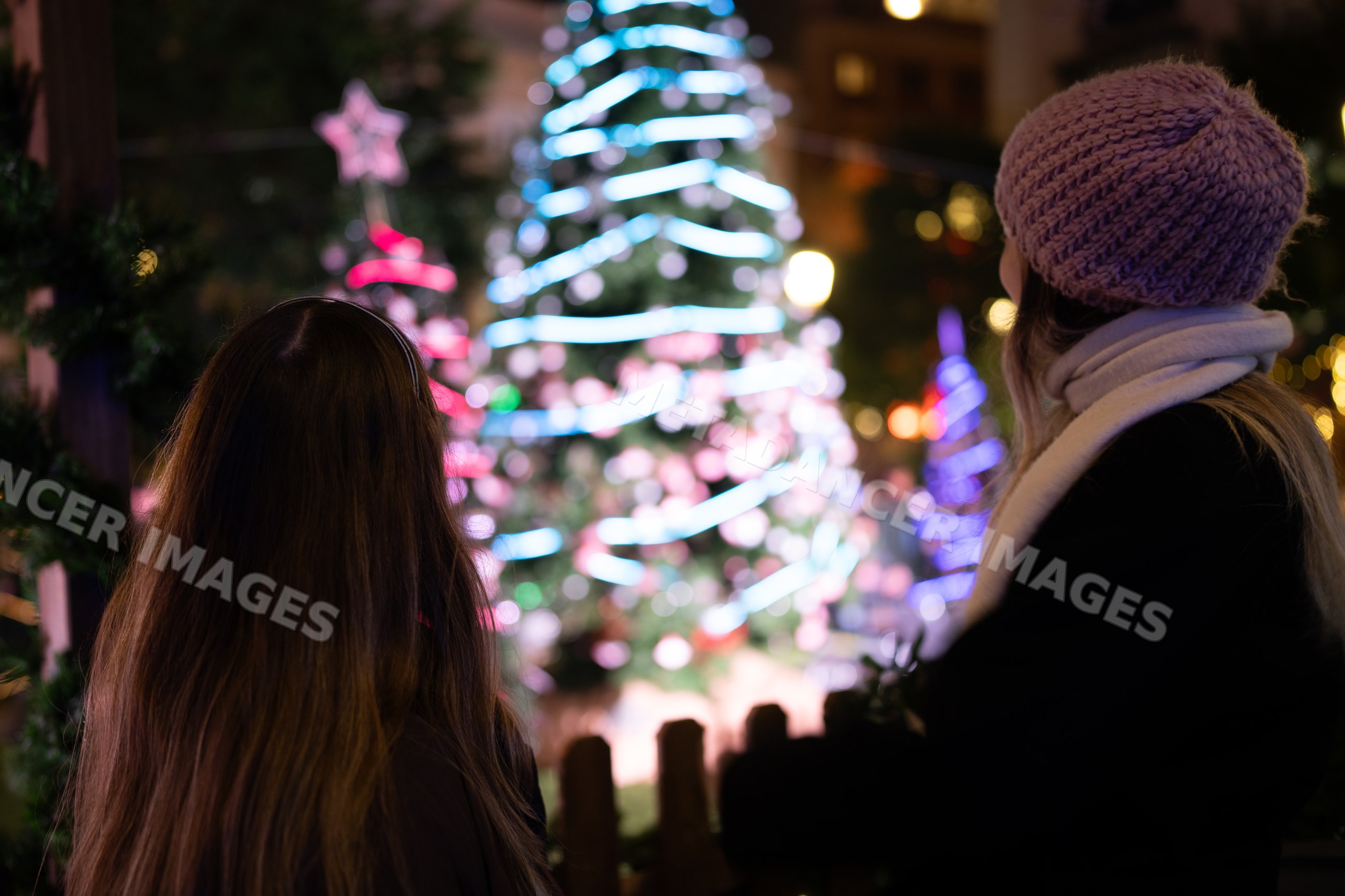 White women admiring illuminated christmas tree
