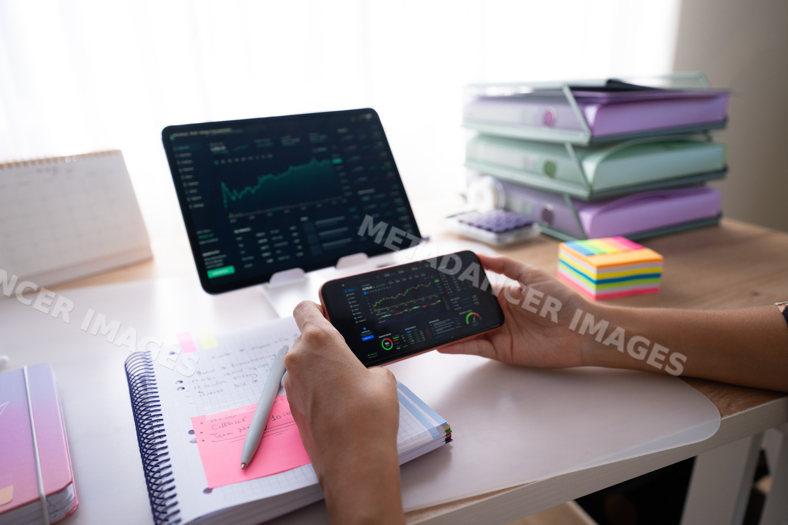 Tablet and smartphone displaying financial data on desk