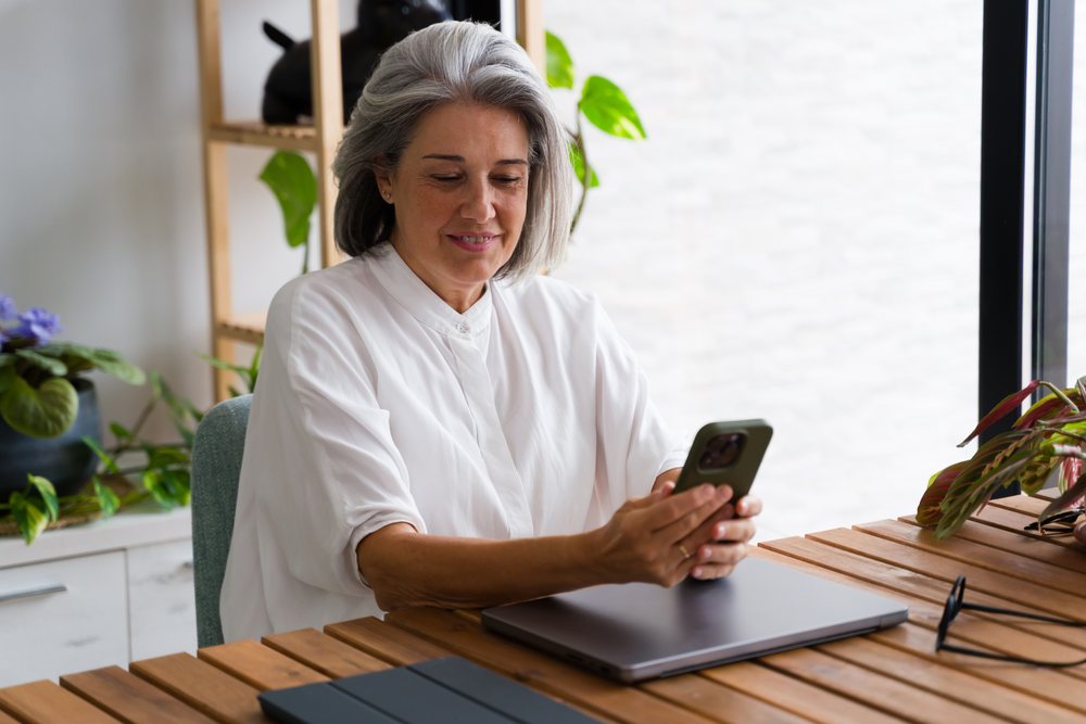 Mature white woman using smartphone indoors