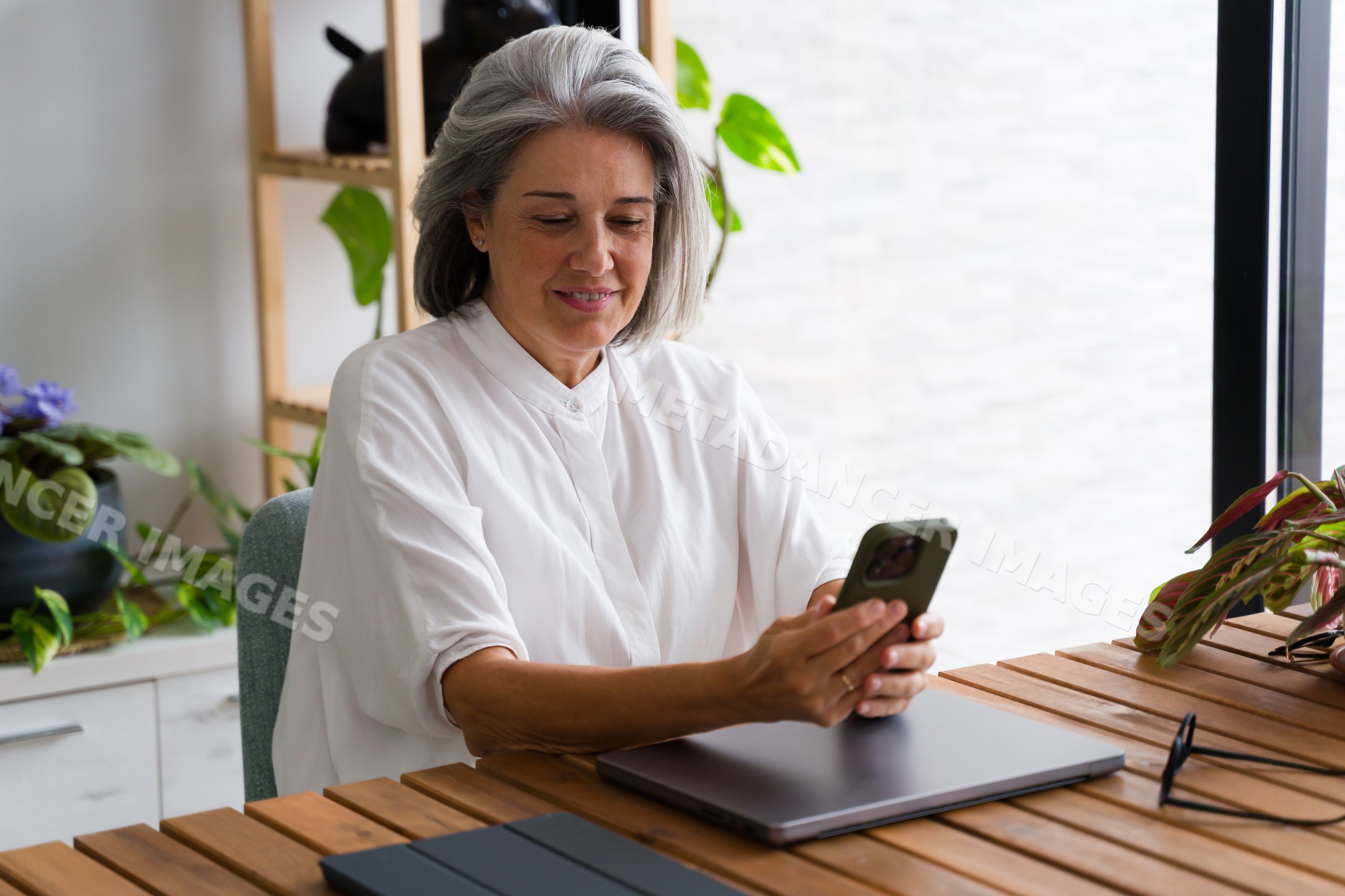 Mature white woman using smartphone indoors