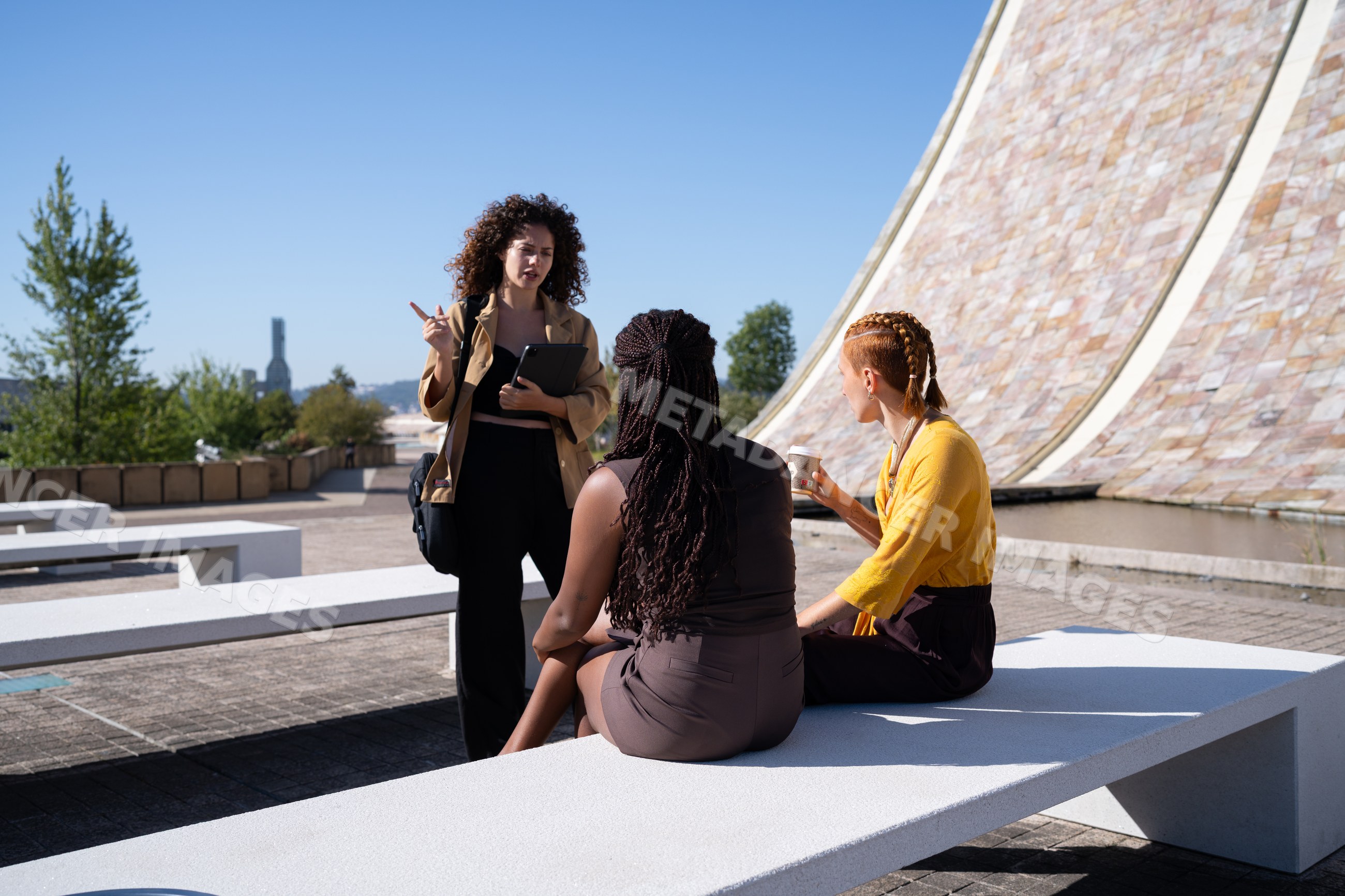 Three African American and white women conversing outdoors