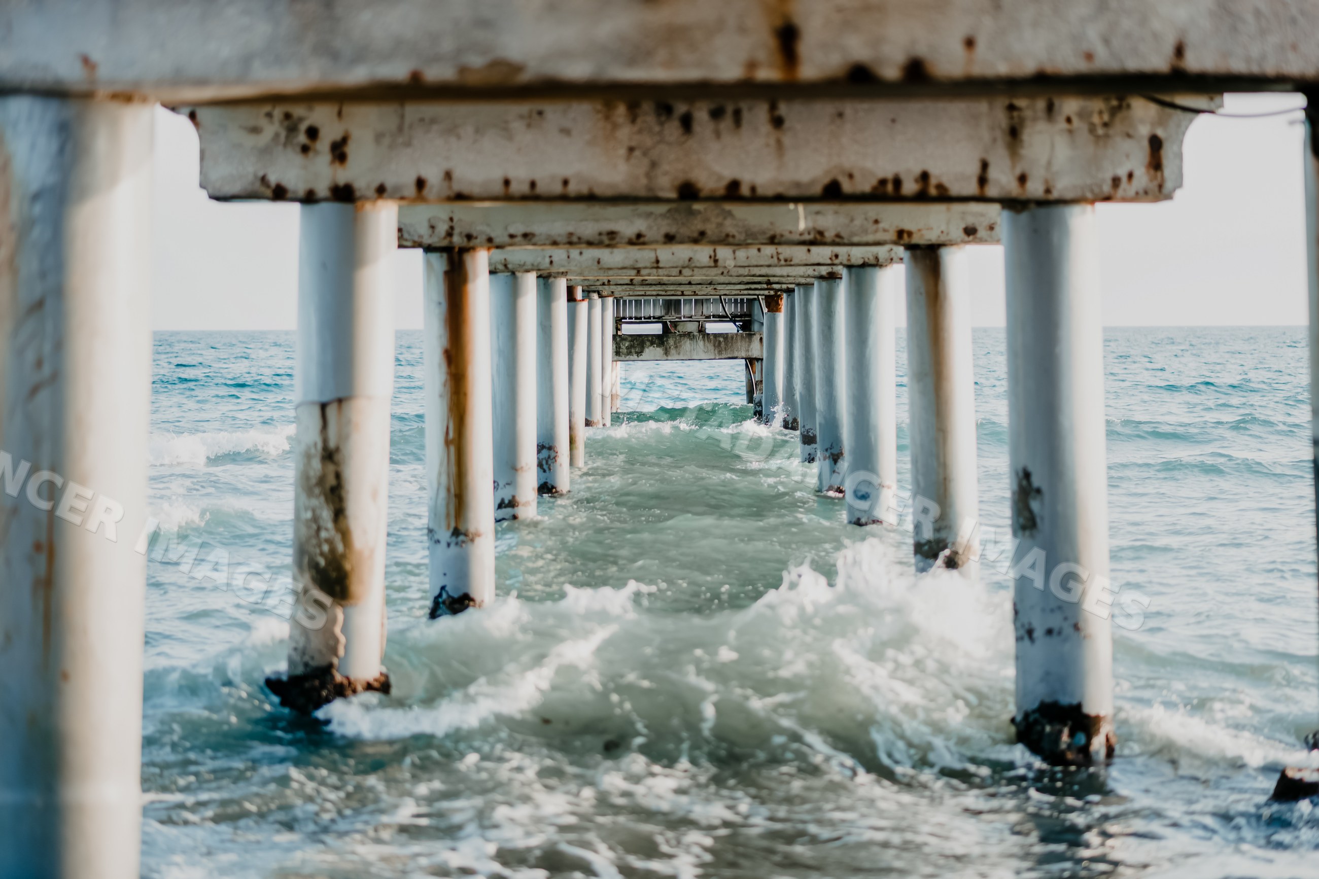 Rusty pier with crashing ocean waves at spanish coast
