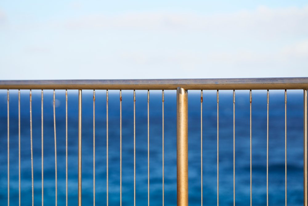 Metal fence overlooking ocean in outdoor coastal setting at Oahi