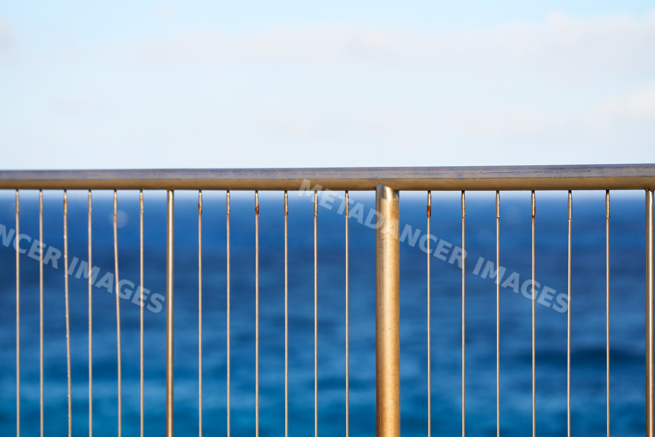 Metal fence overlooking ocean in outdoor coastal setting at Oahi