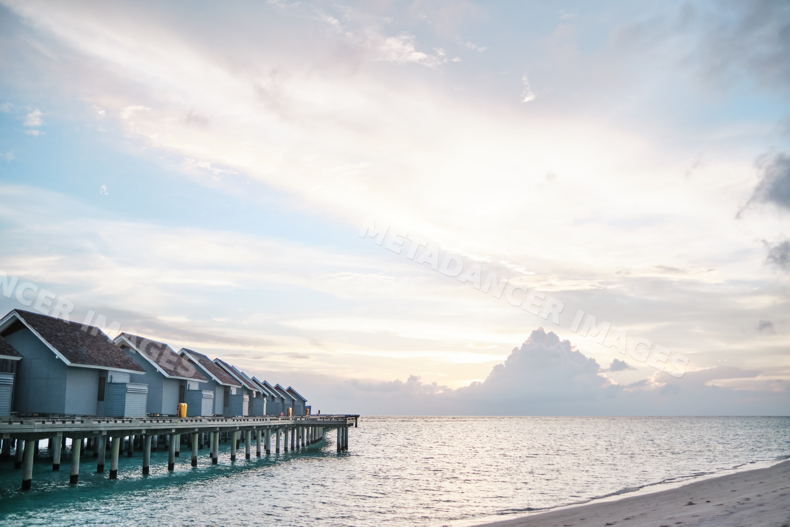Sunset over overwater bungalows on a wooden pier
