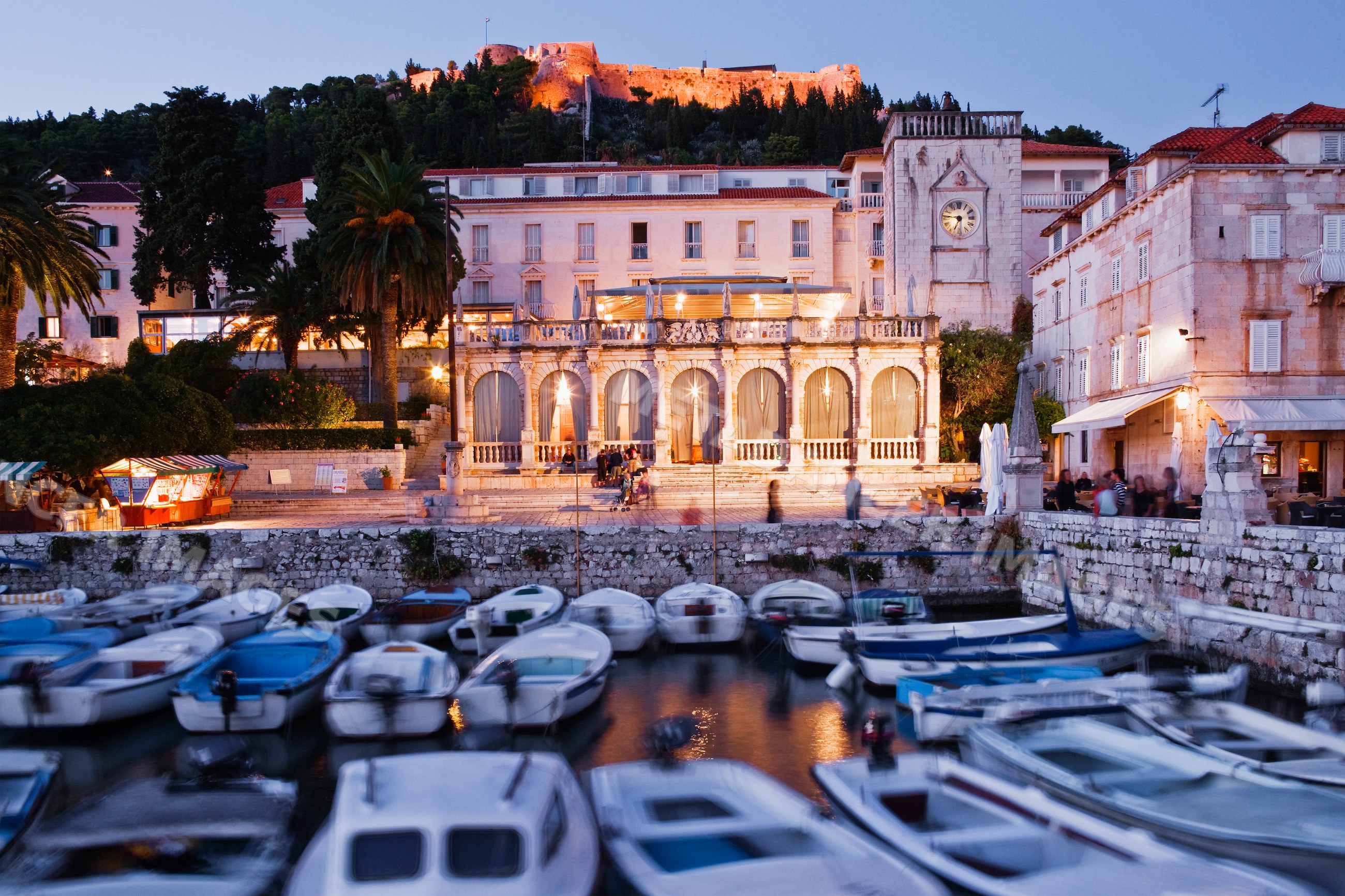 Boats docked with illuminated historic buildings
