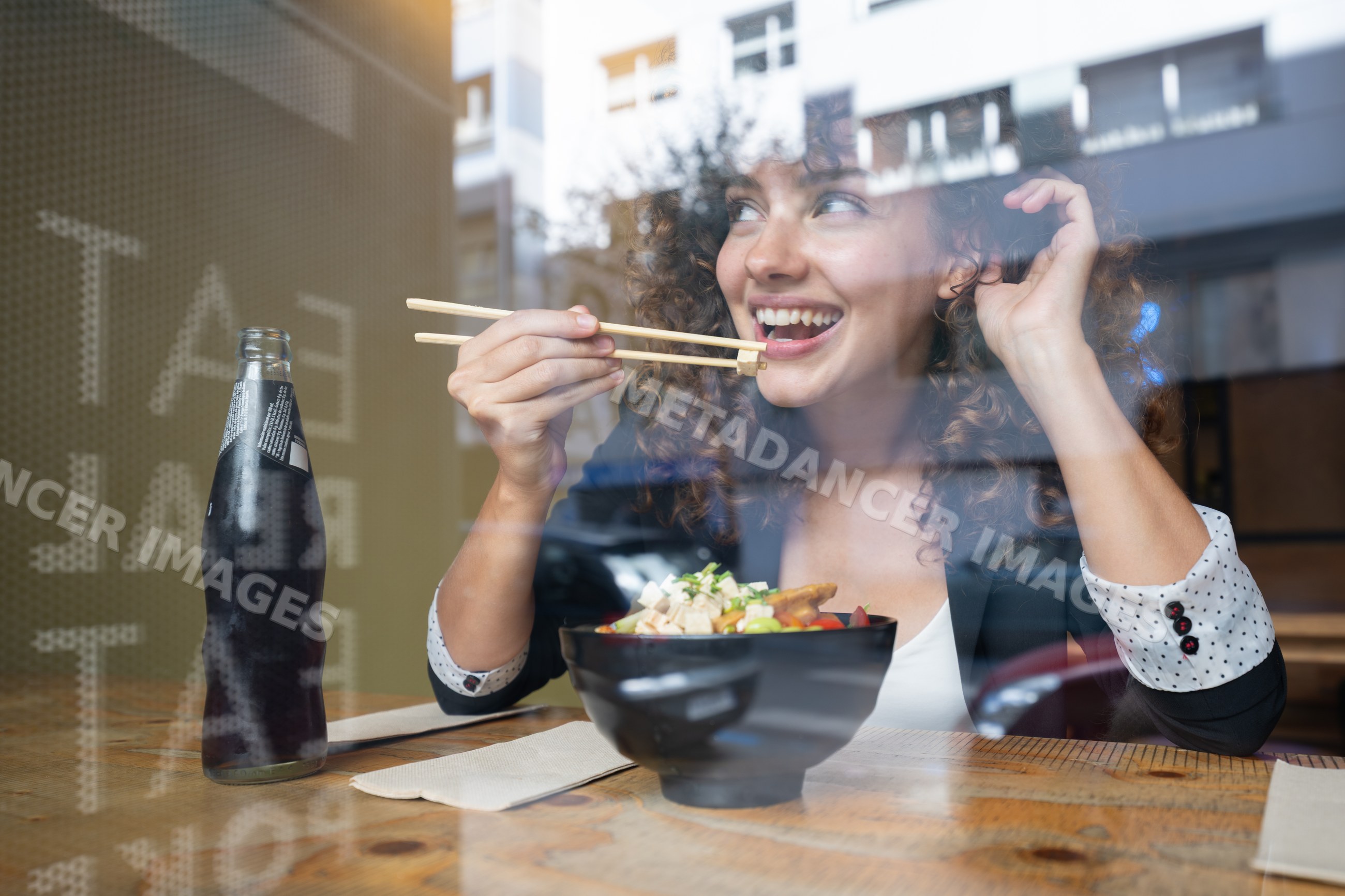 White woman eating asian food with chopsticks