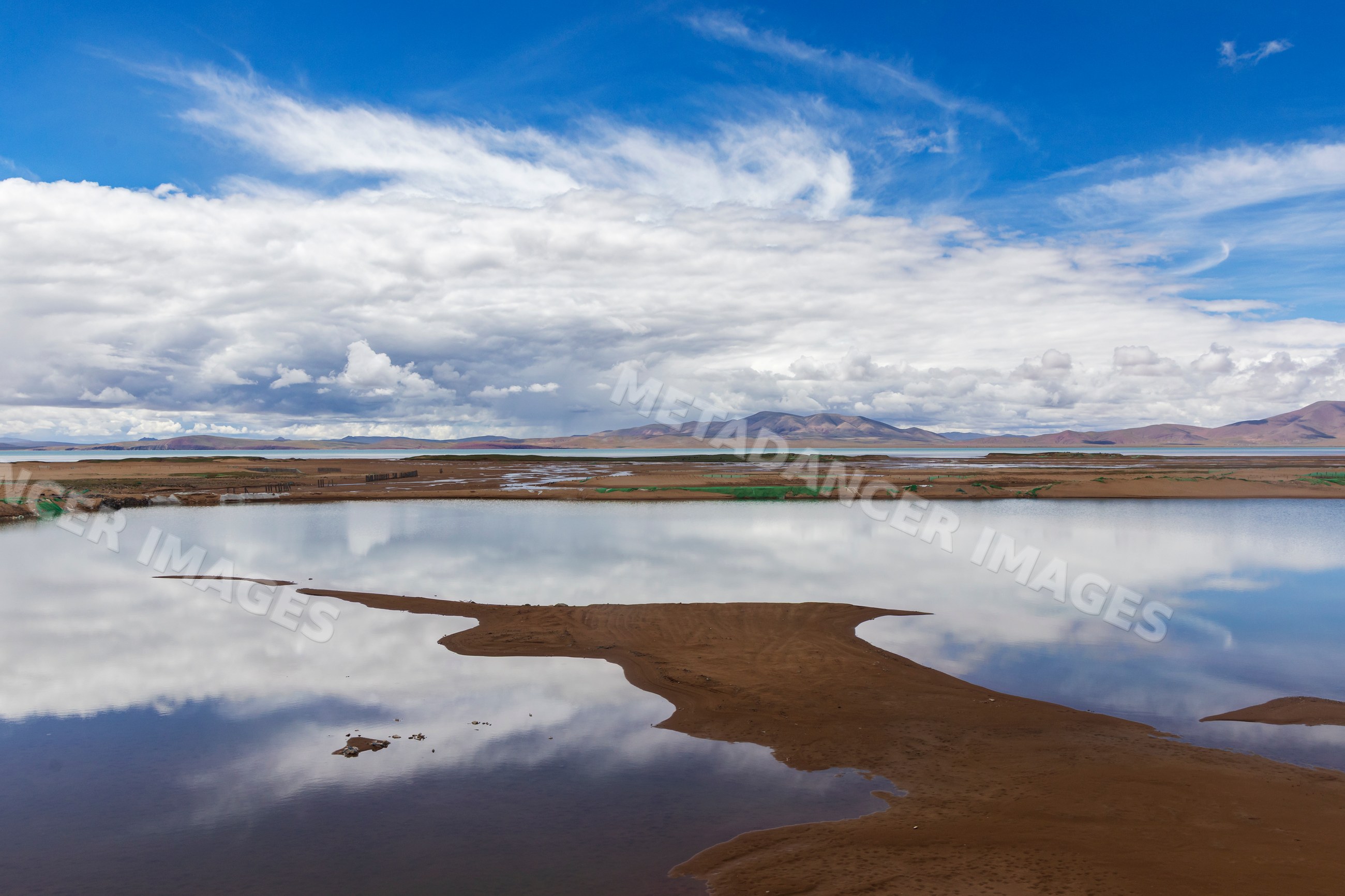 Lake Kuona reflecting clouds and mountains in amdo county tibet