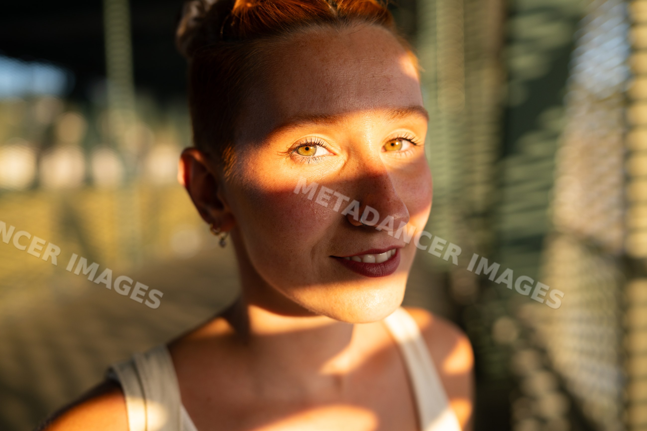 Young woman enjoys warm sunlight and shadows in an urban setting