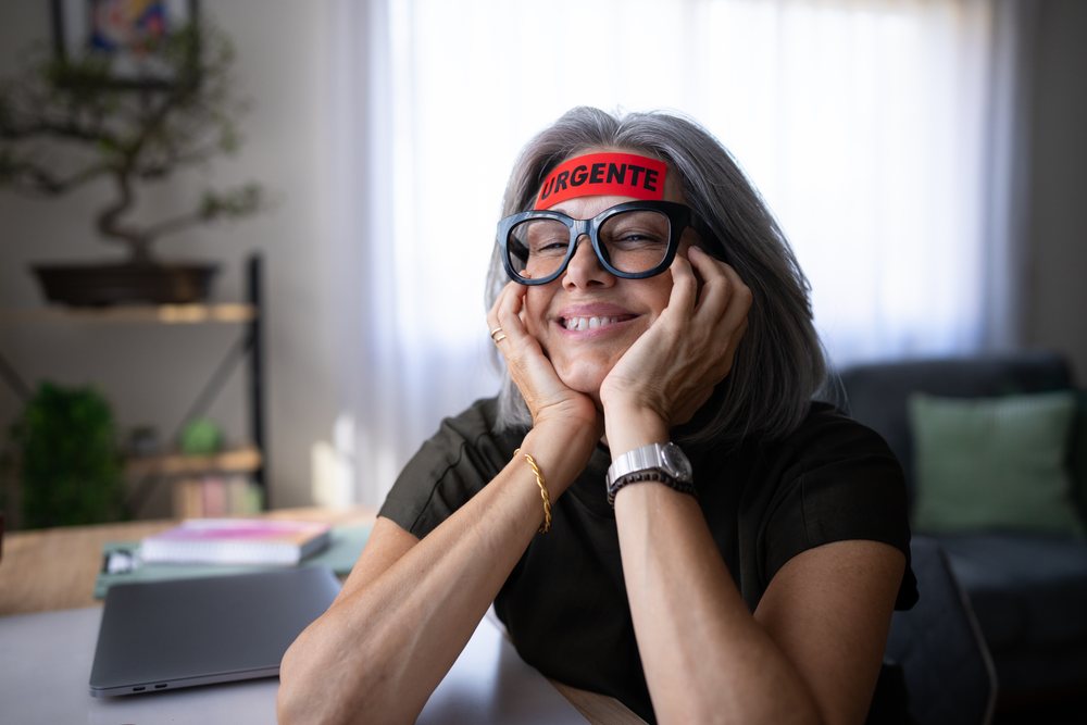 White woman resting face on hands and smiling indoors