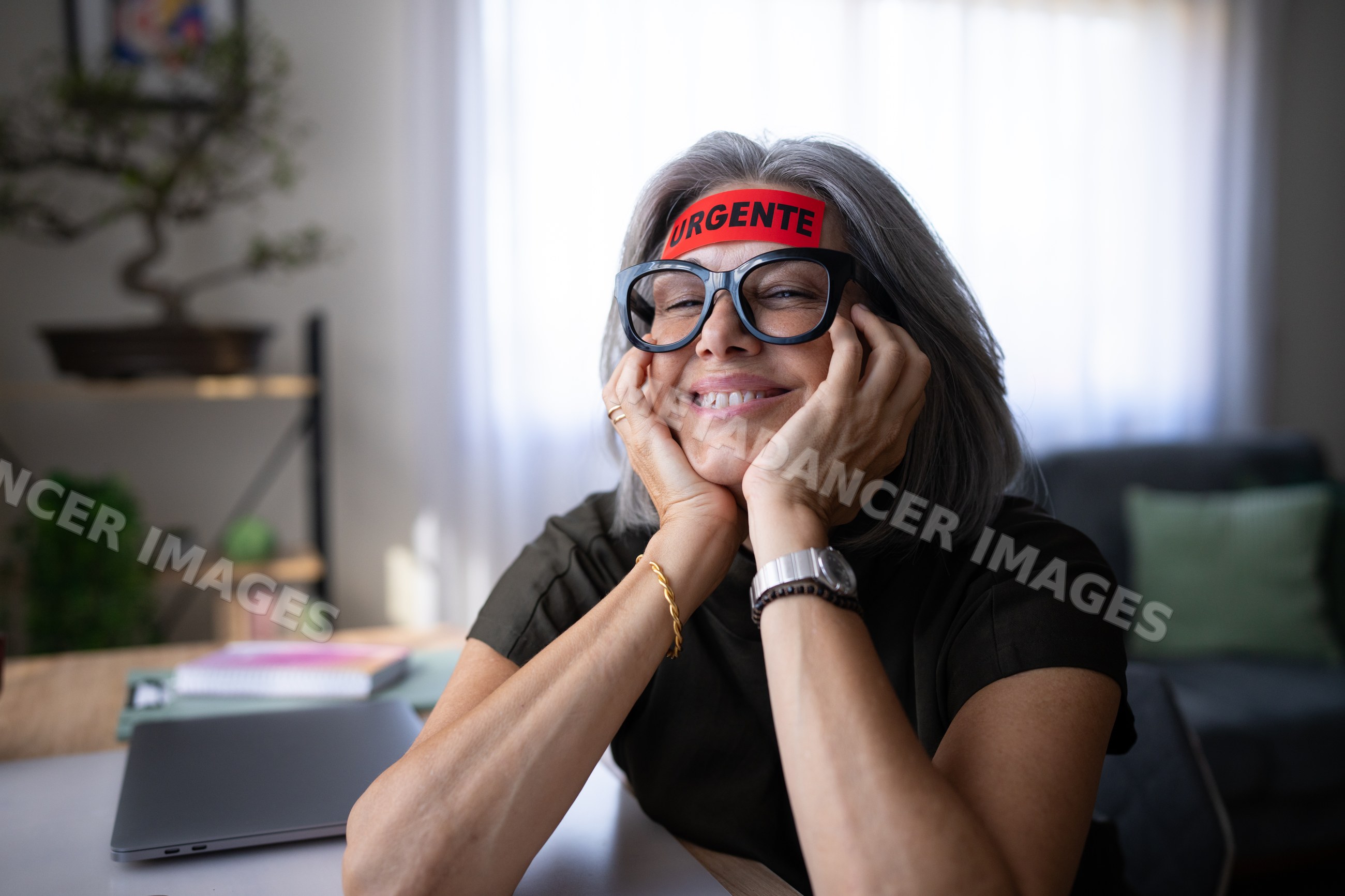 White woman resting face on hands and smiling indoors