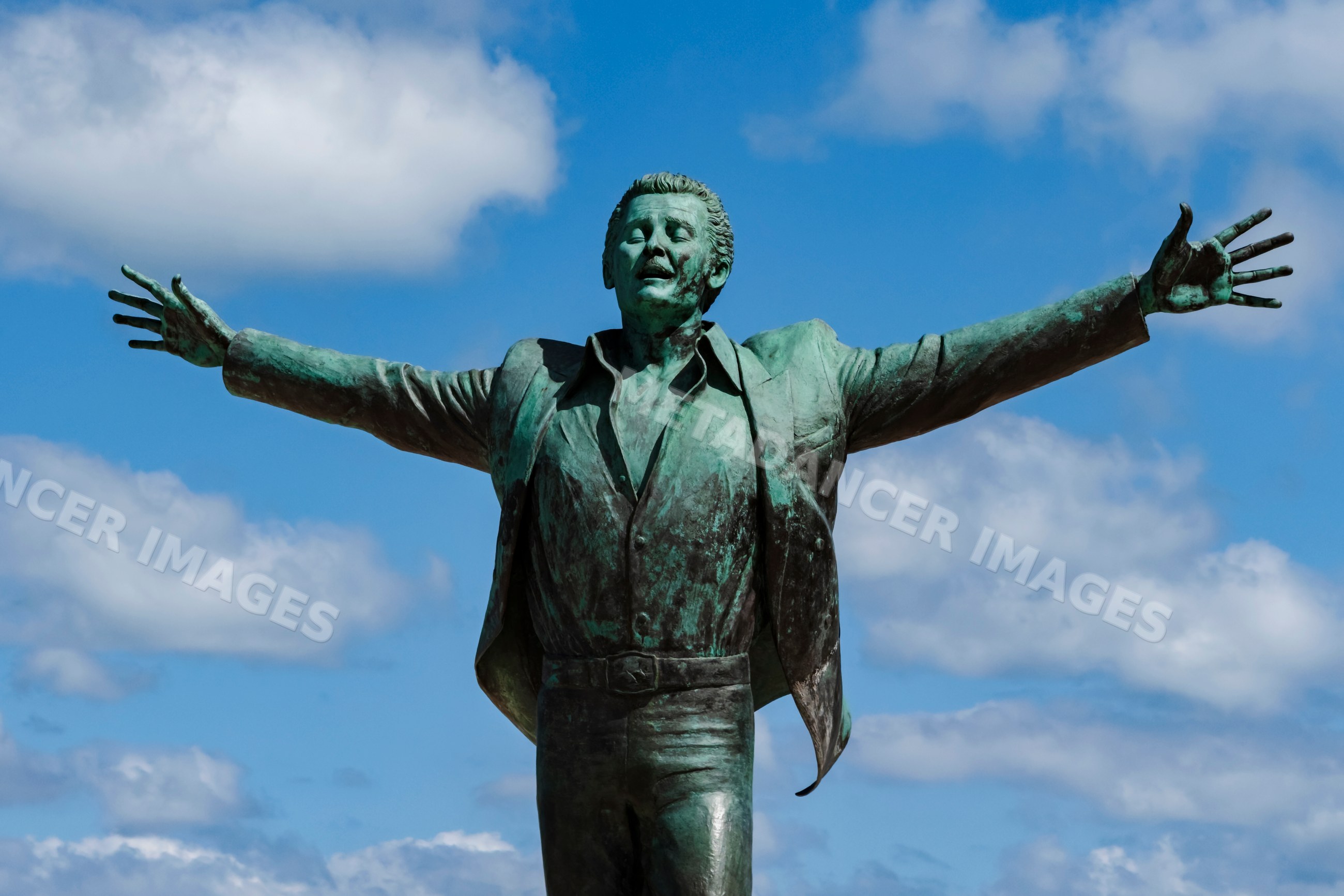 Statue of Domenico Modugno with arms outstretched in polignano a mare