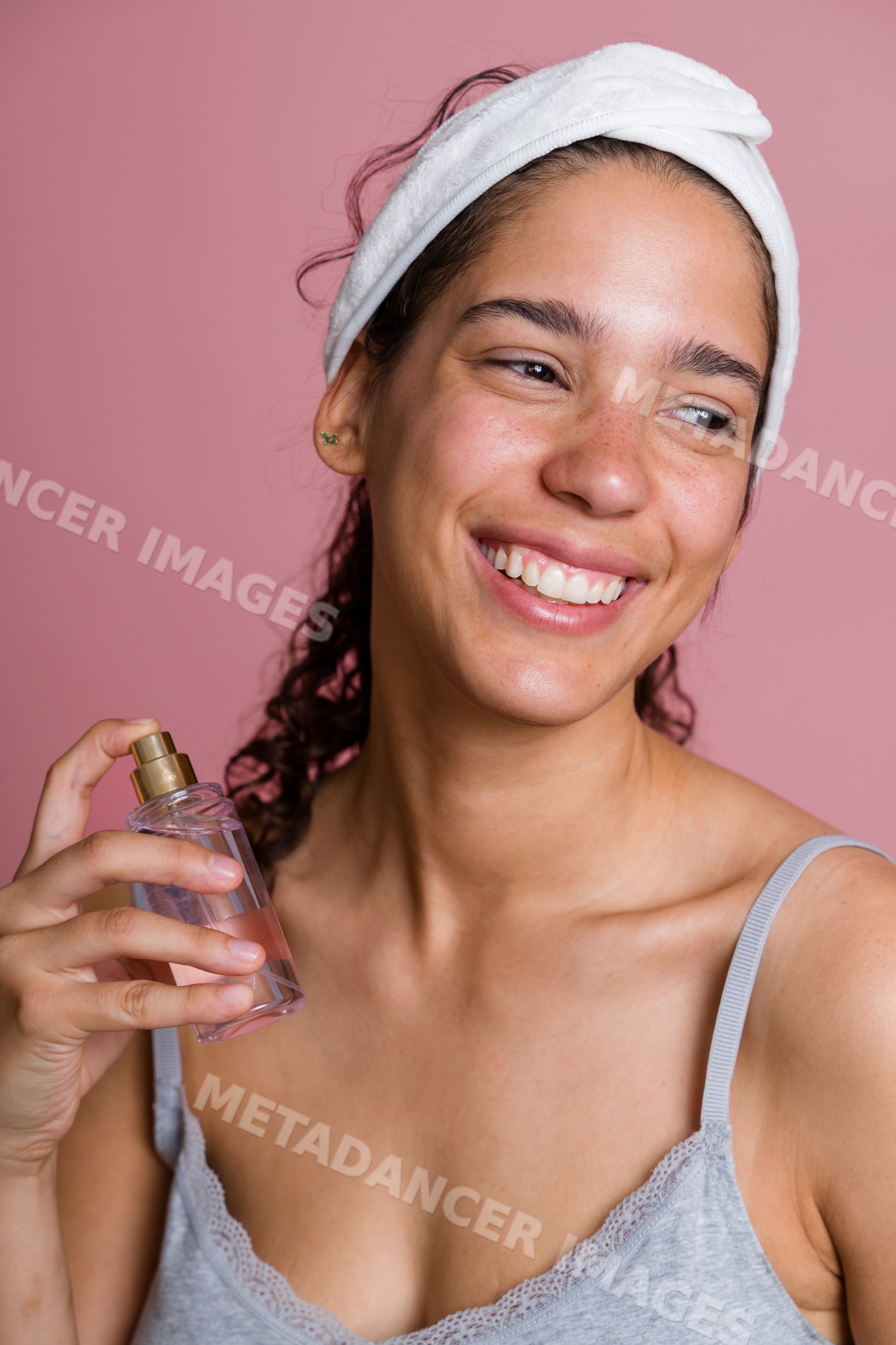 Hispanic woman holding facial spray bottle in beauty shoot in Spain