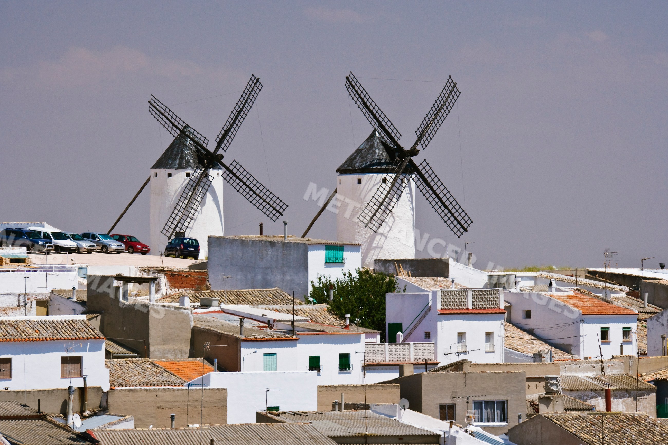 White windmills over rooftops, la mancha, Spain