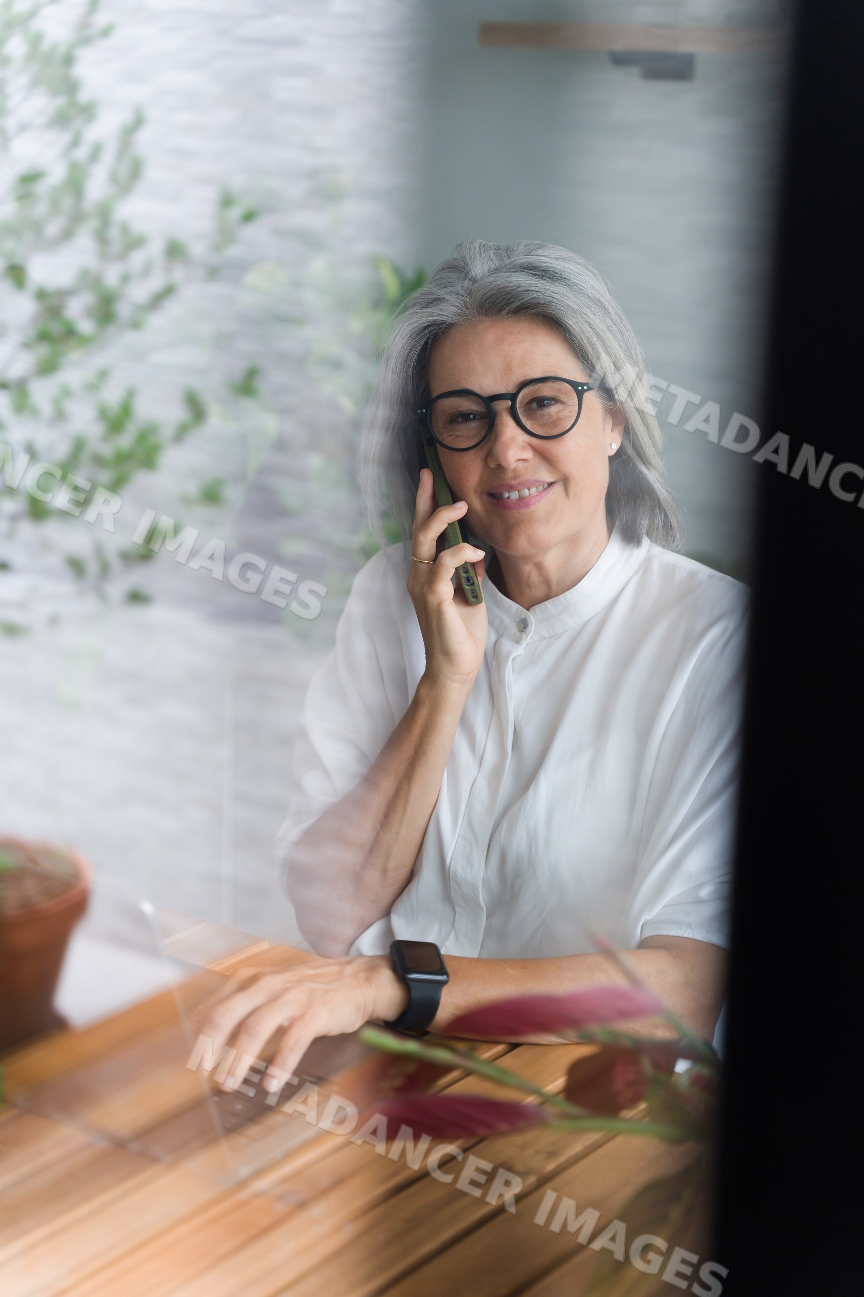 White Woman with gray hair making phone call