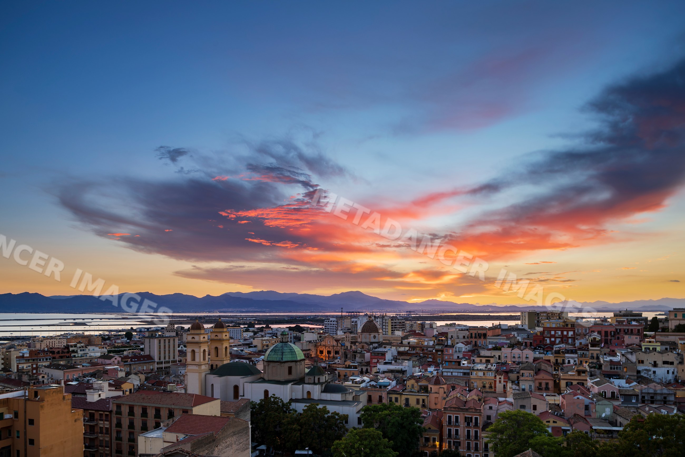 Cagliari city skyline at Sunset with colorful clouds and mountains