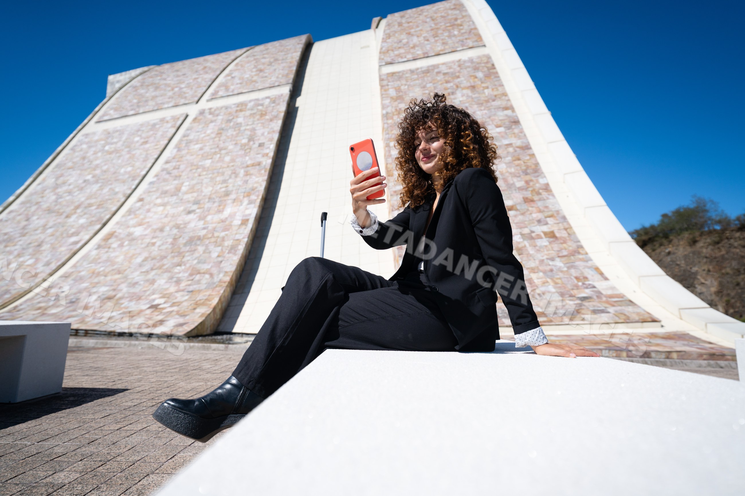 Businesswoman taking selfie outside modern architecture
