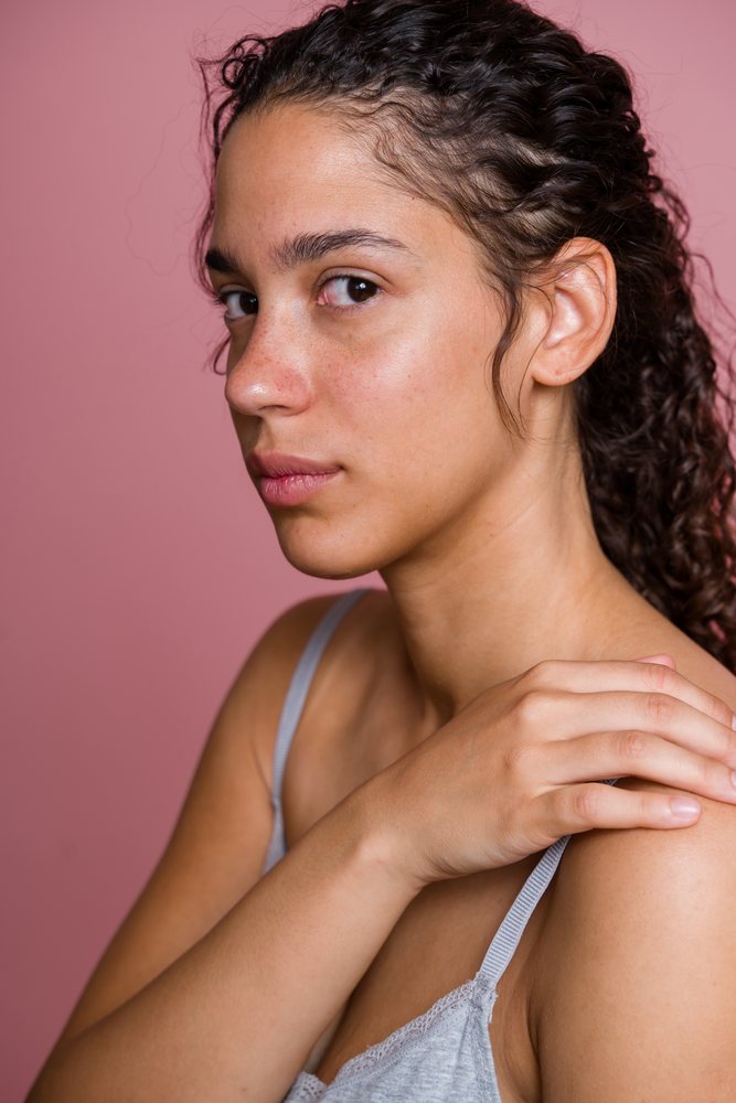 Portrait of Hispanic woman with curly hair touching shoulder