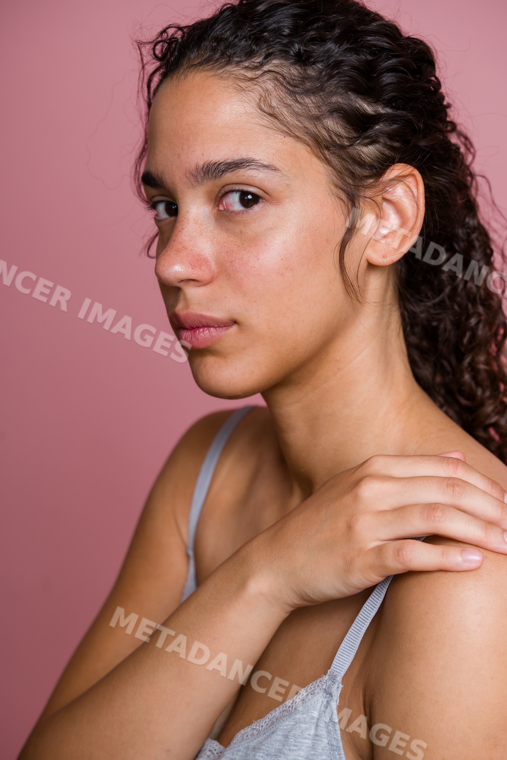 Portrait of Hispanic woman with curly hair touching shoulder