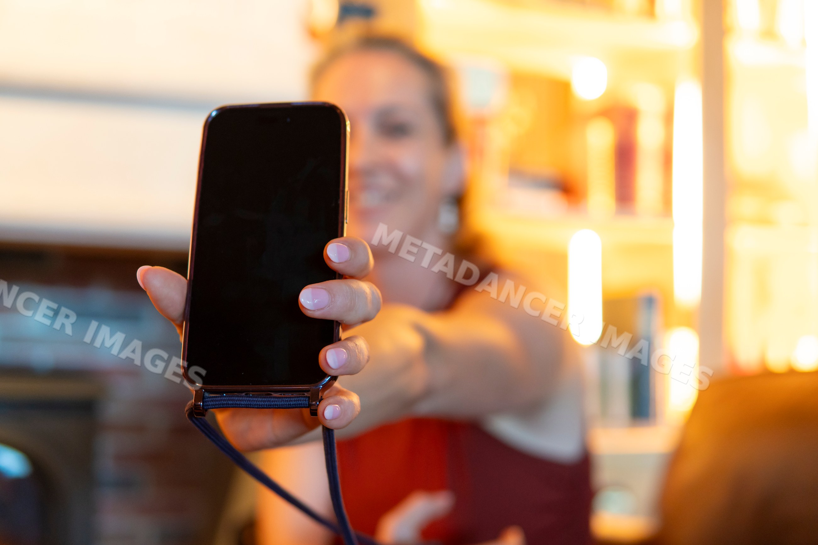 A woman shows a device screen indoors in a living room in Verdun