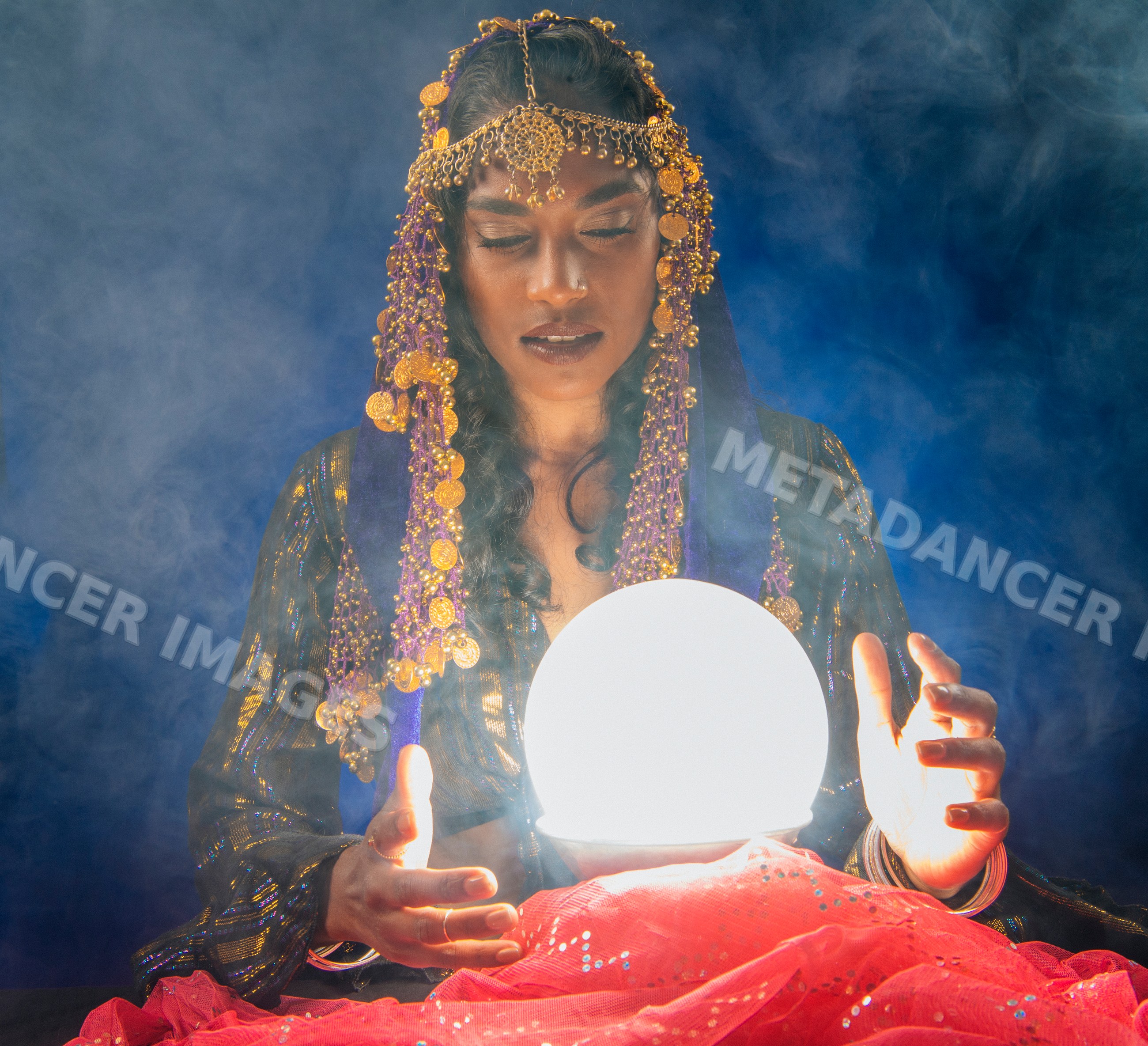 A South Asian woman holding a glowing crystal ball for fortune telling