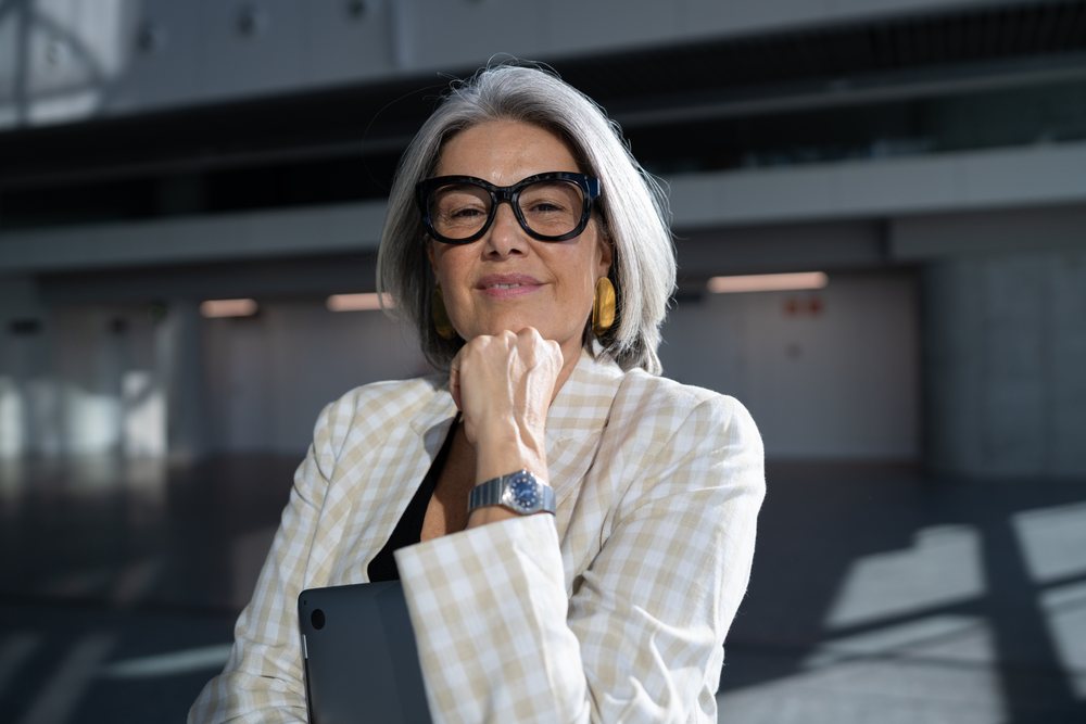 Confident white woman holding laptop