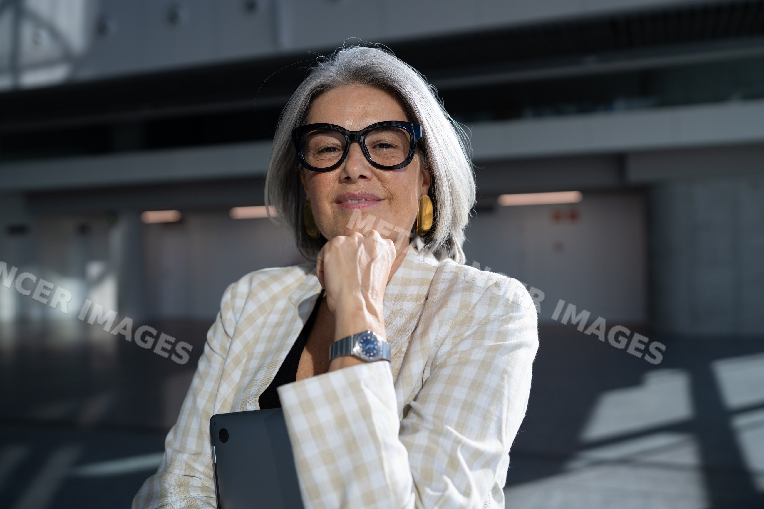 Confident white woman holding laptop