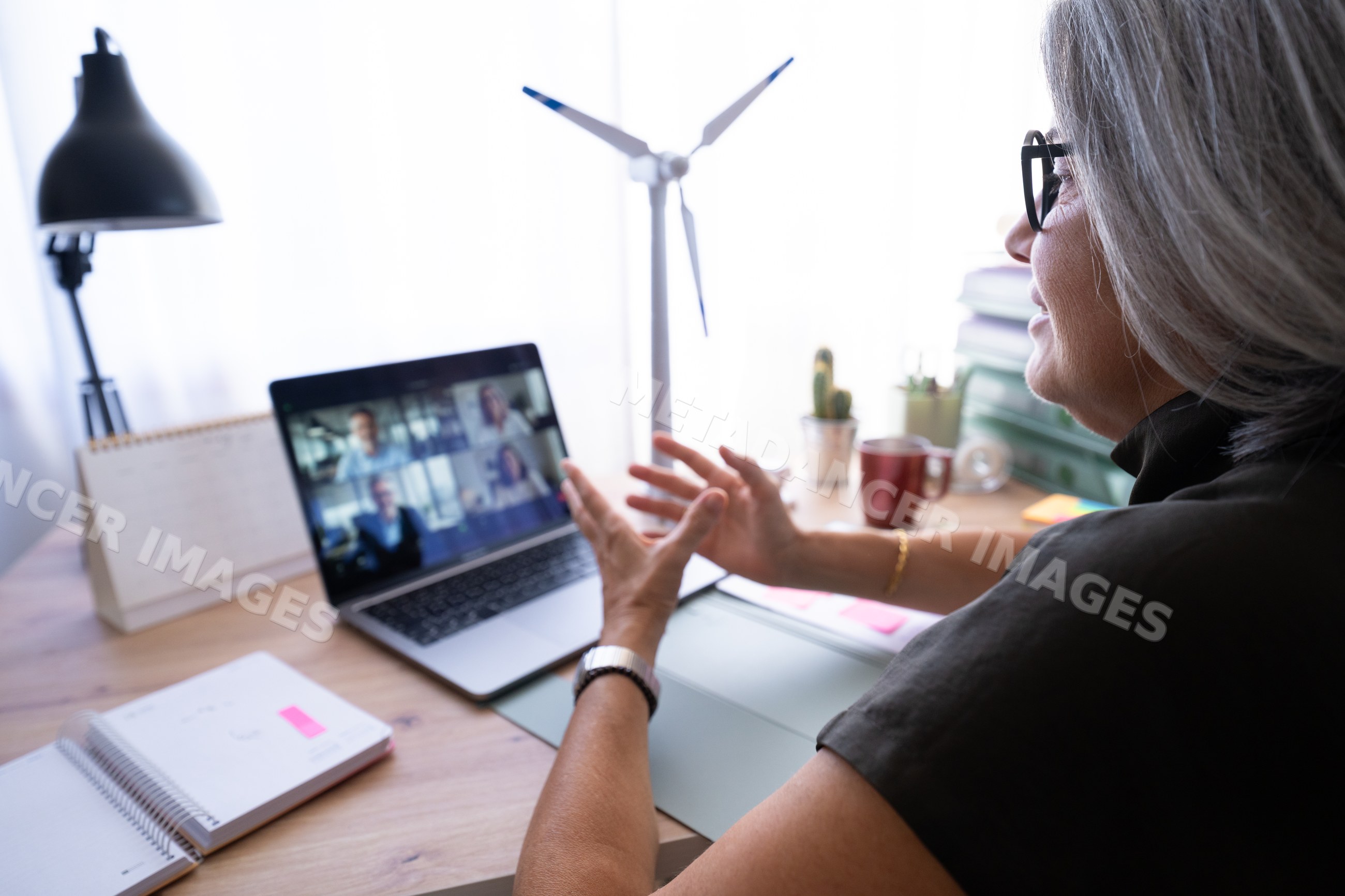 White woman joining a video call from her home office desk