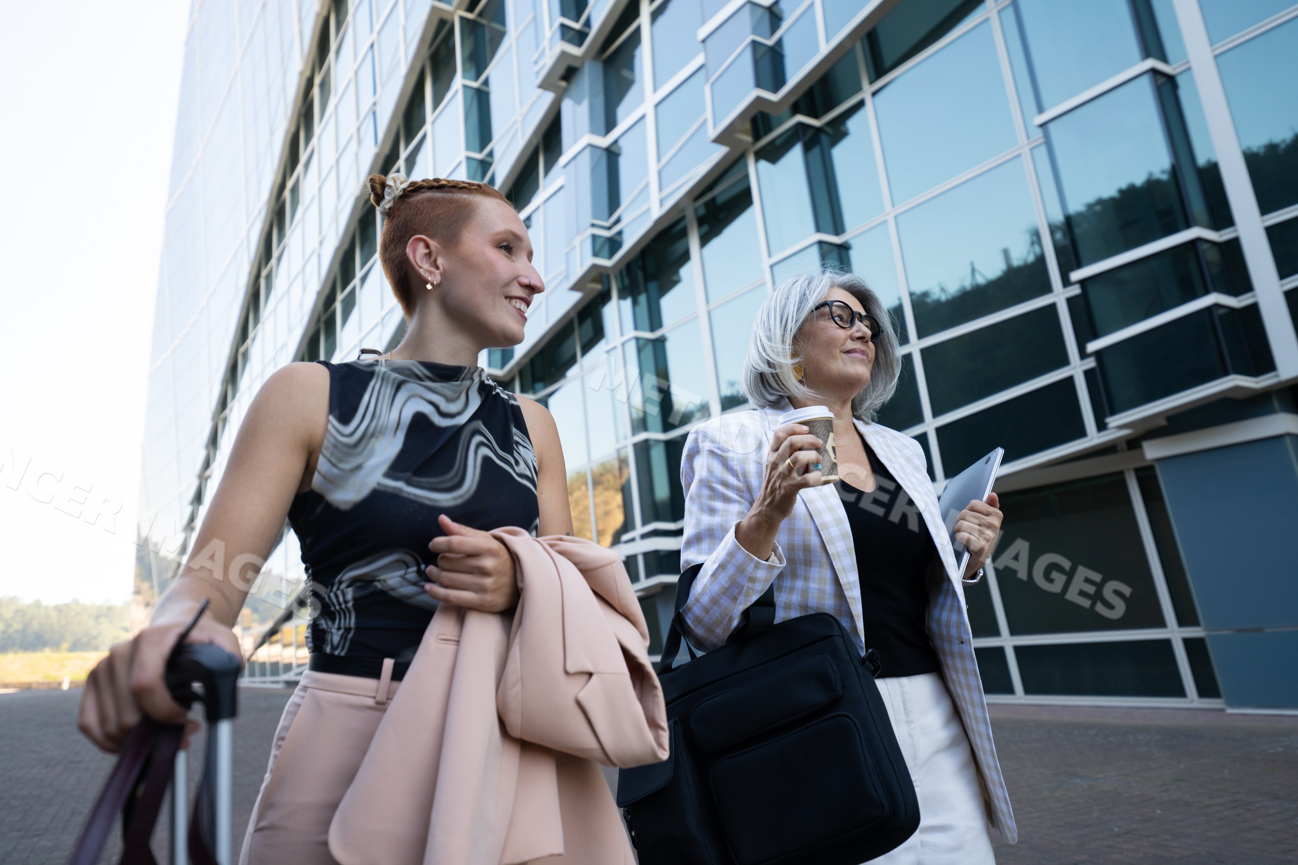 Businesswomen walking outside modern office building in a office