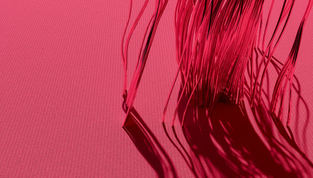 Close-up of red threads casting detailed shadows on a textile surface