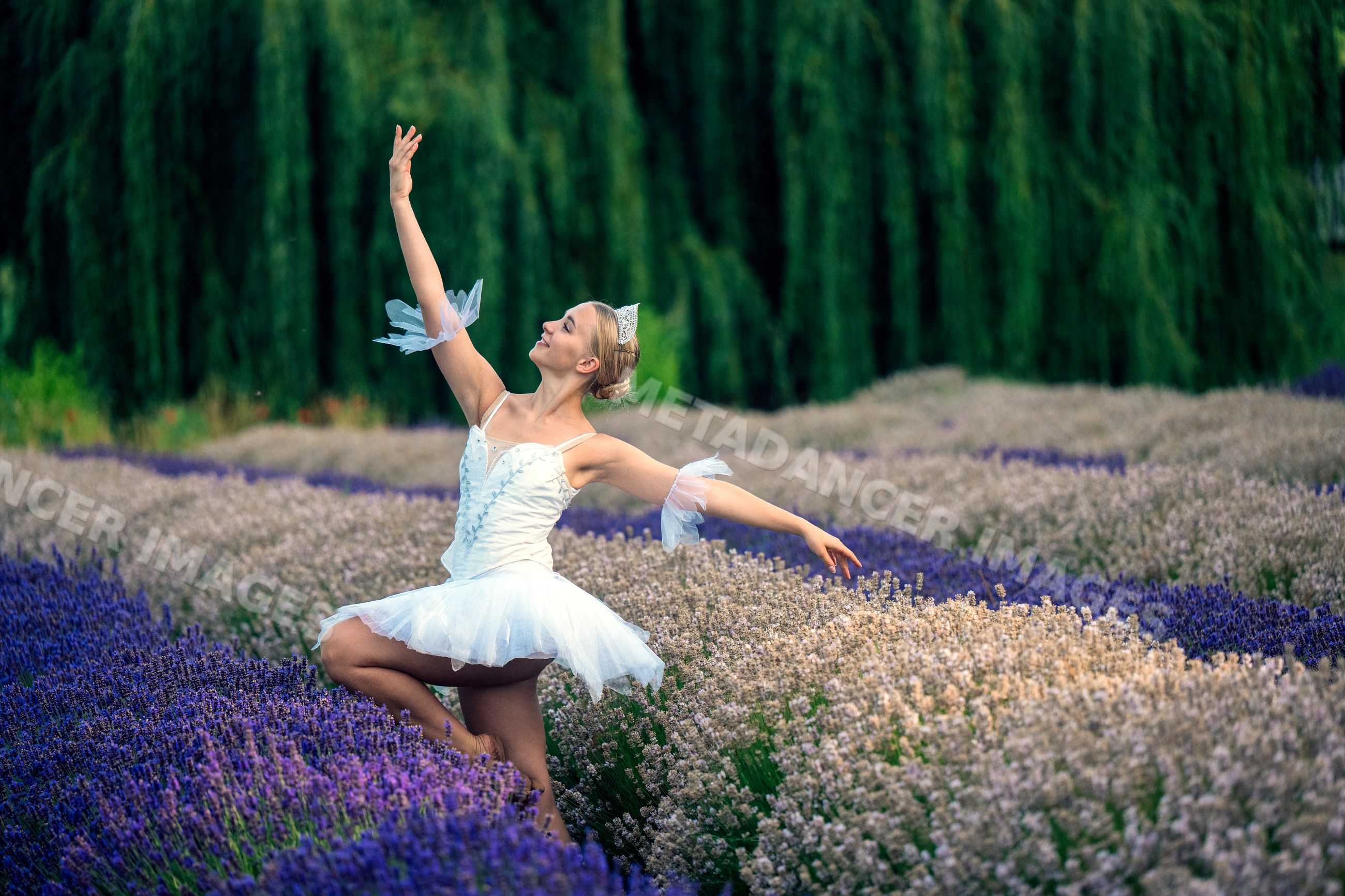 A white dancer poses gracefully outdoors