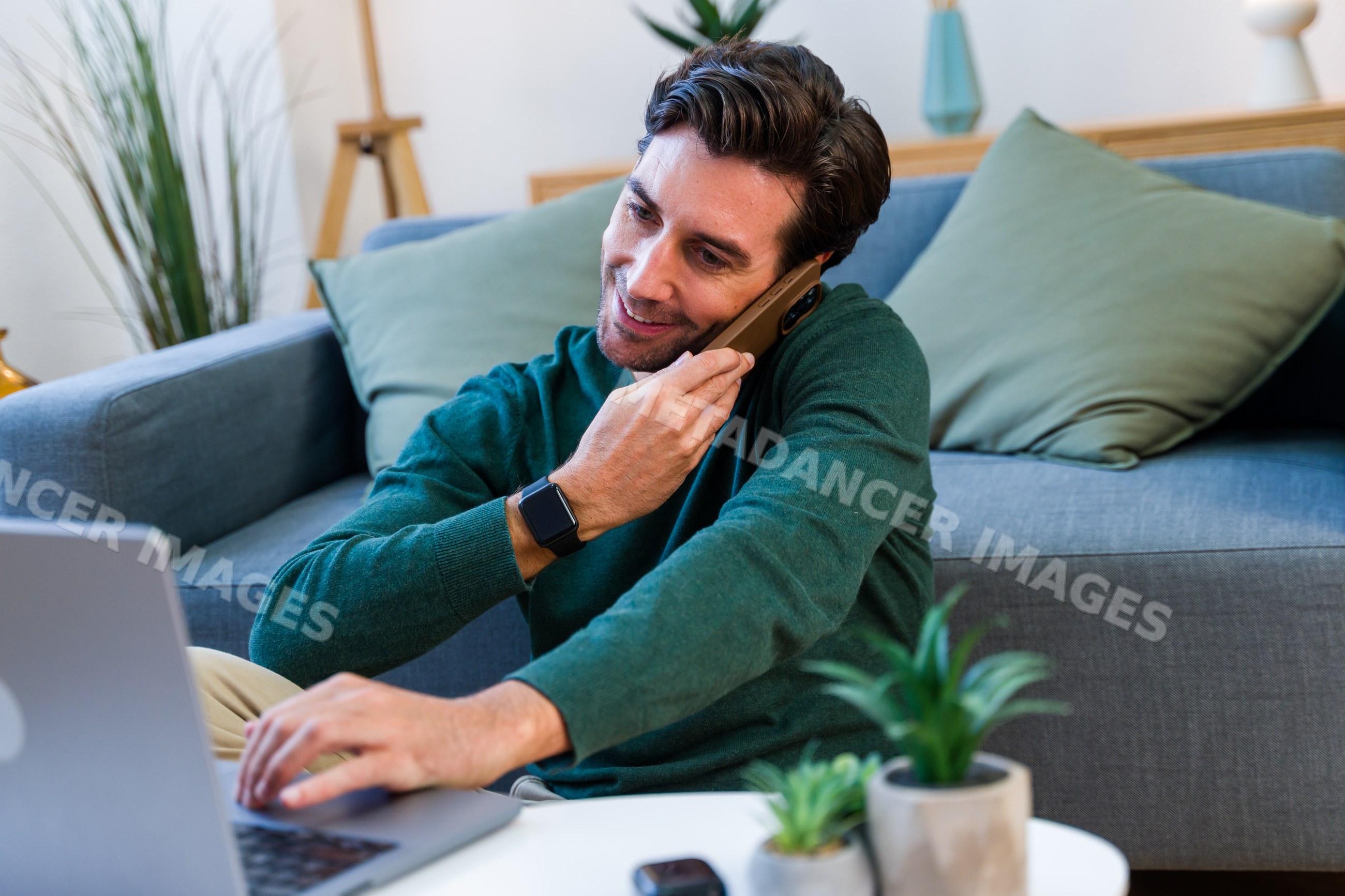 White man multitasking with laptop and phone