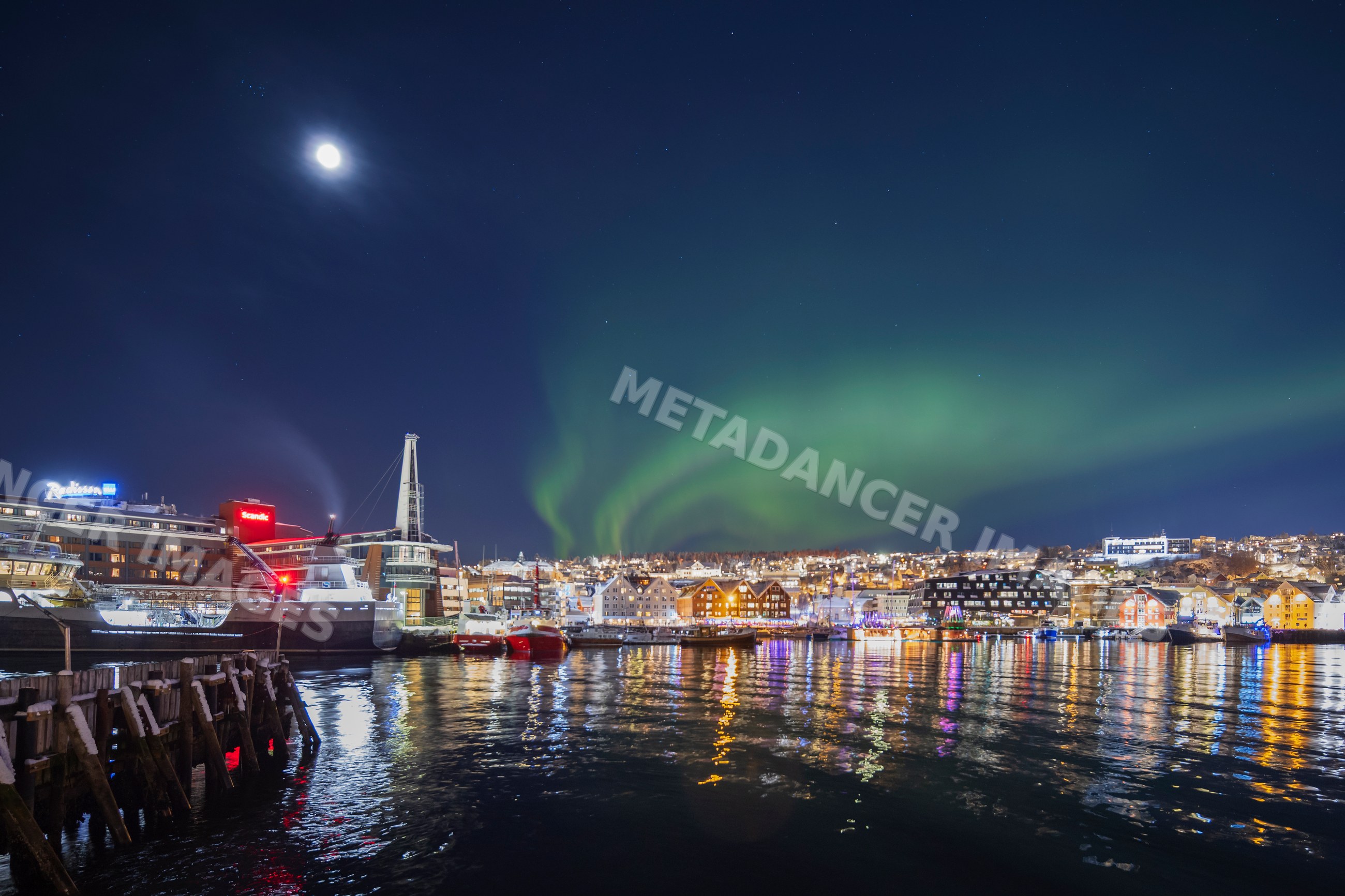 Northern Lights over tromsø harbor at night in Norway
