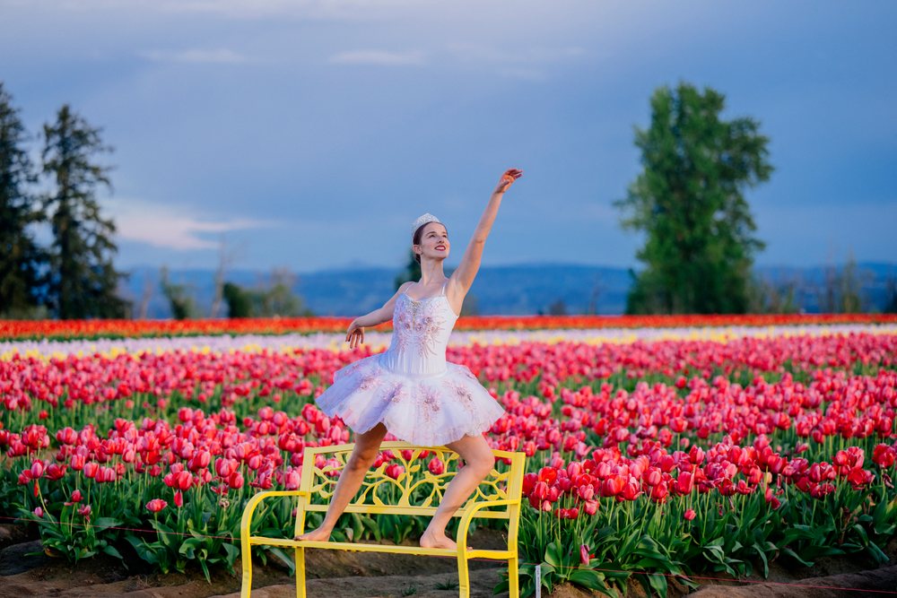 Ballet white dancer posing gracefully on a yellow bench