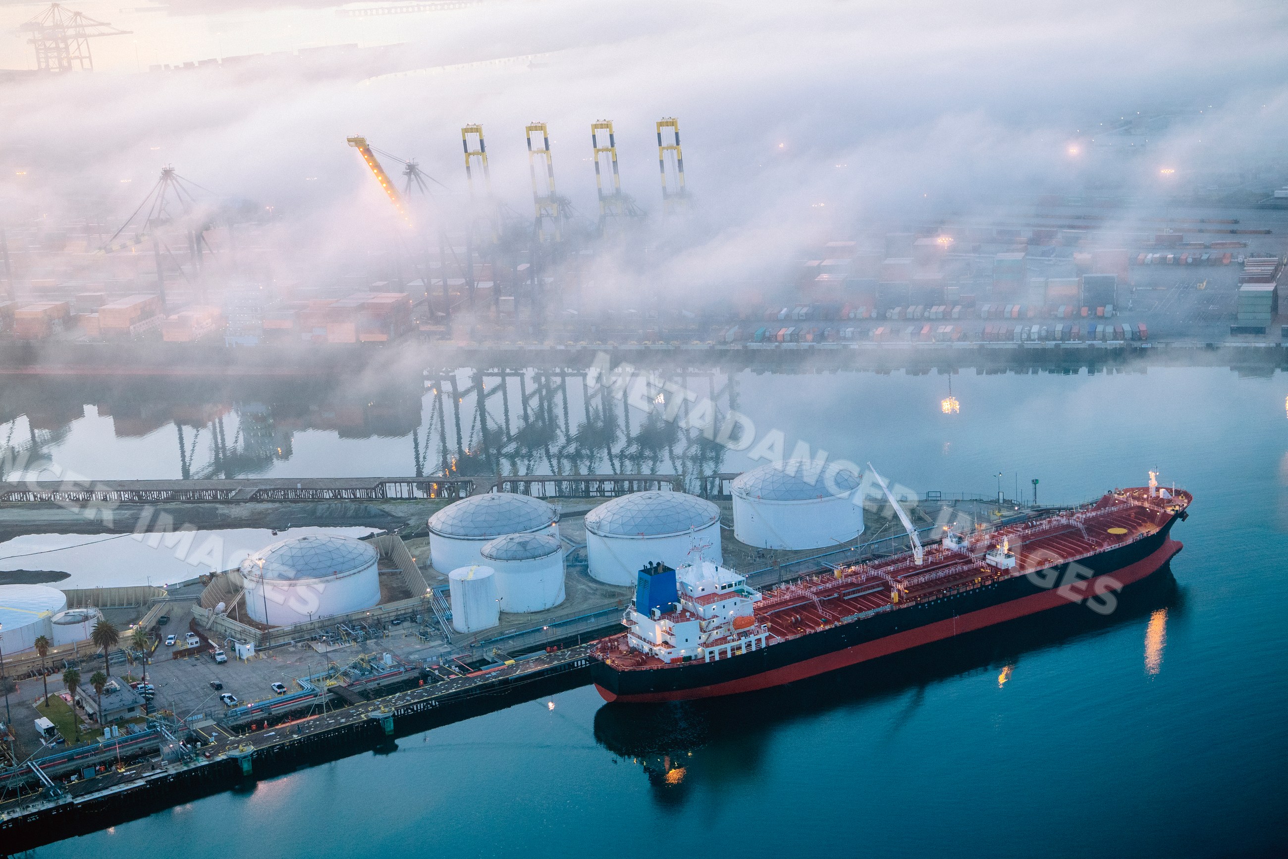 Cargo ship docked near oil storage tanks in a beach