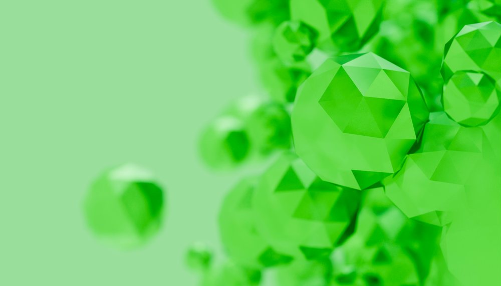 Green abstract faceted crystals clustered against smooth green