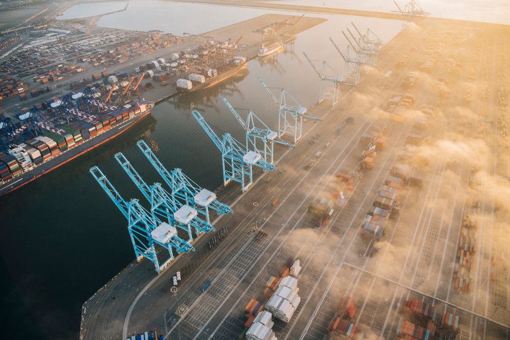 Aerial view of shipping cranes and cargo containers at a port in Long