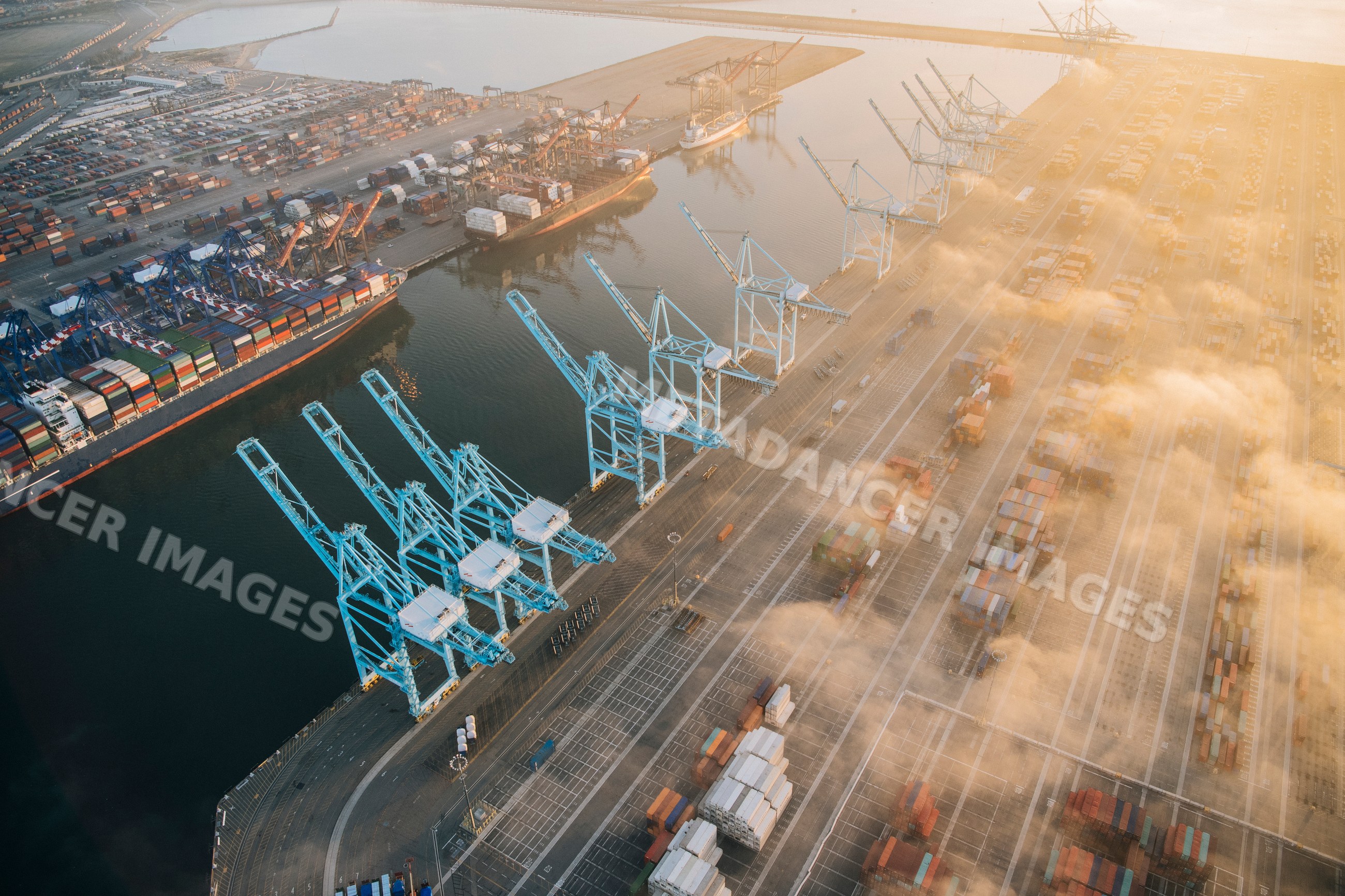Aerial view of shipping cranes and cargo containers at a port in Long