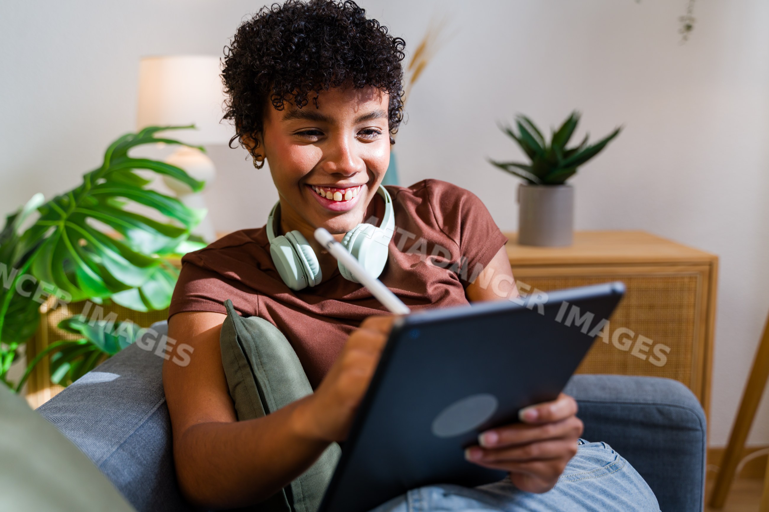 African American woman smiling using tablet with stylus pen