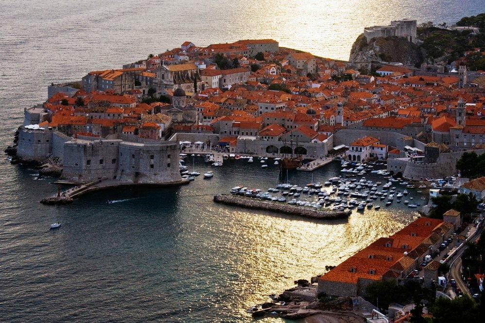 Old city of dubrovnik with boats and fortifications