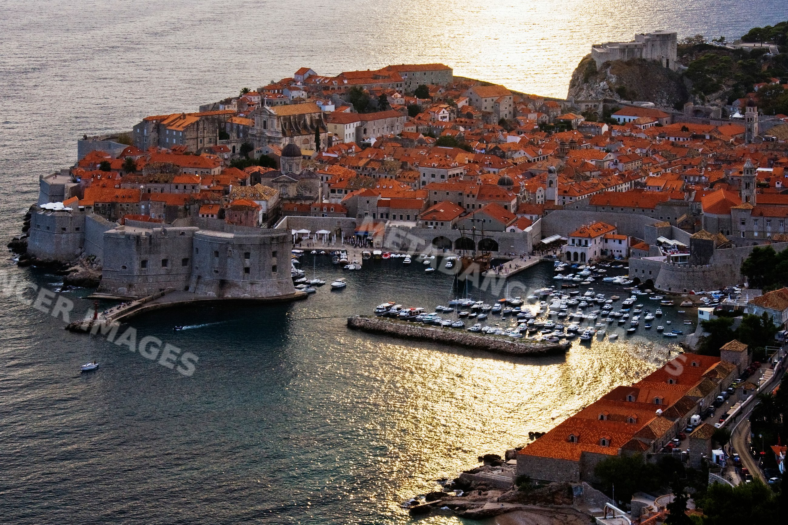 Old city of dubrovnik with boats and fortifications