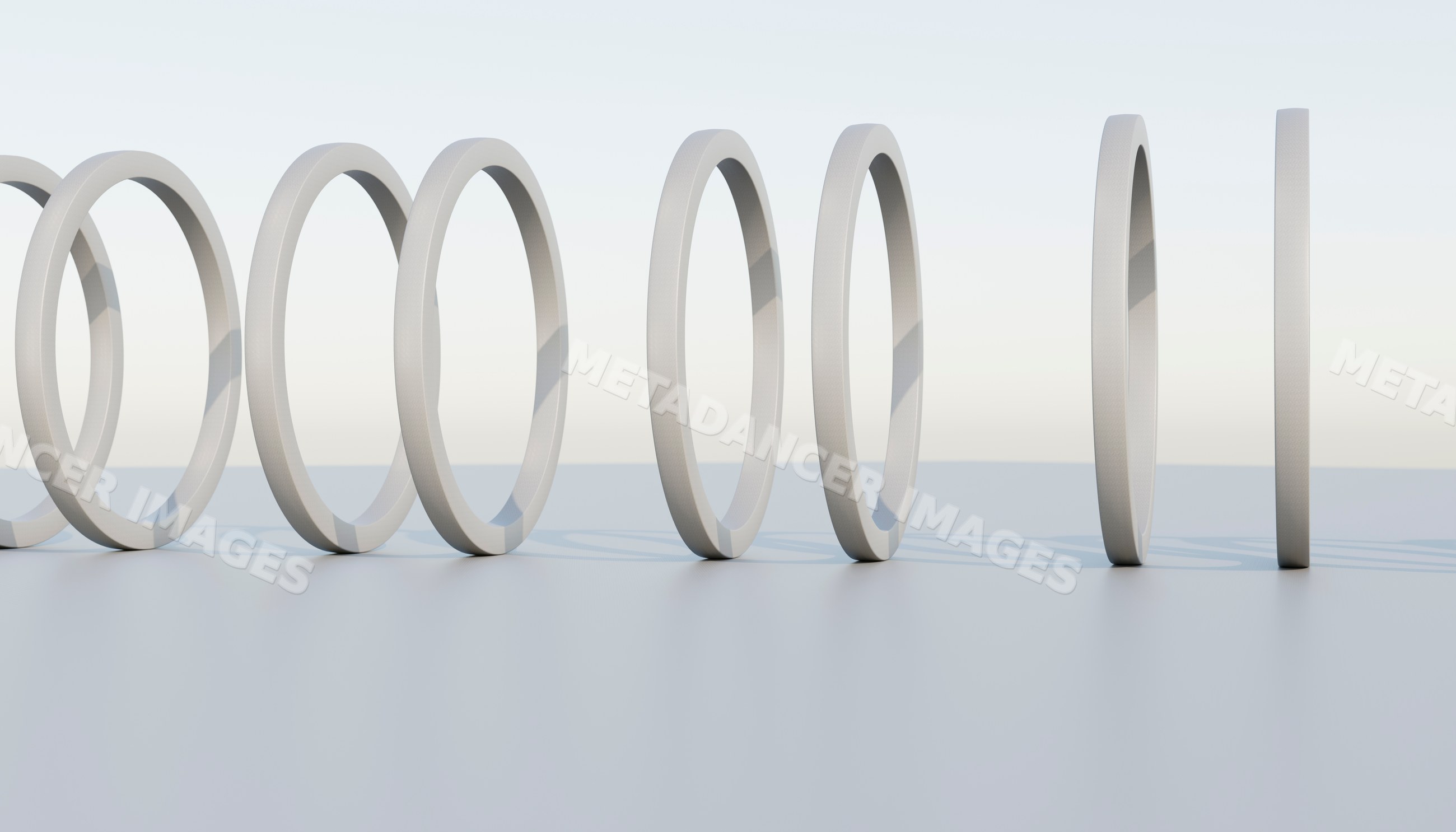 A minimalist sequence of white rings in a clean studio setting