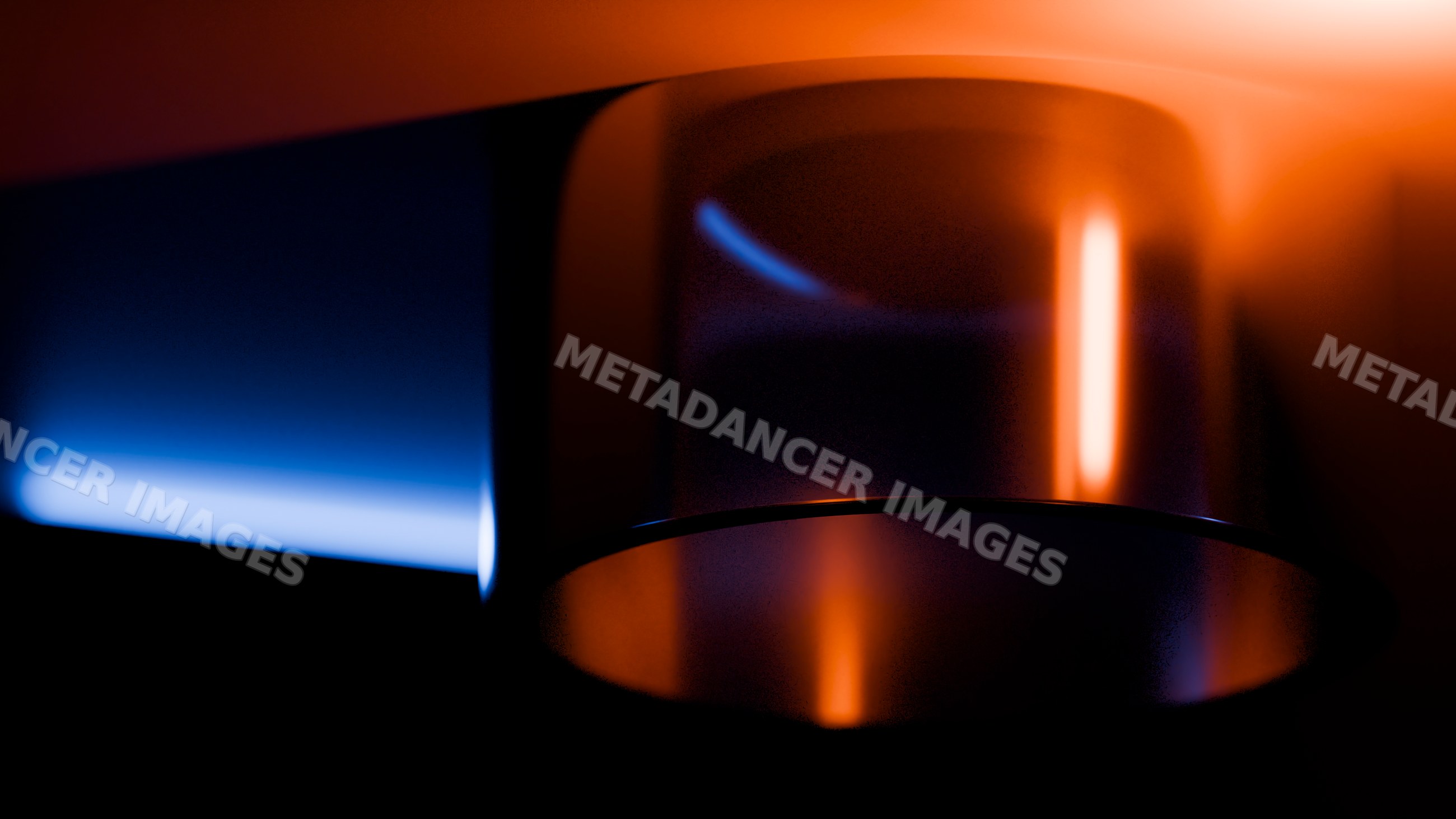 Blue and orange flames on metal gas burner in dark setting