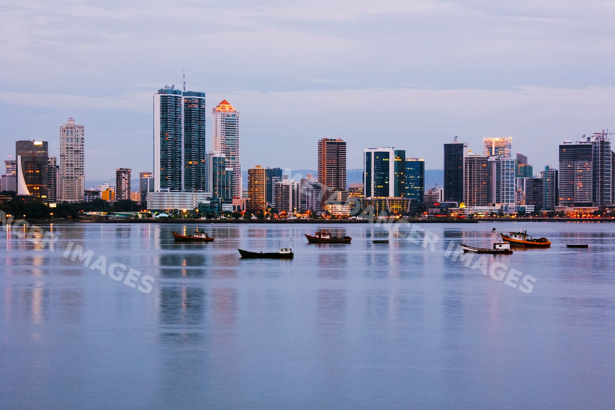 Panama city skyline with boats at dusk harbor